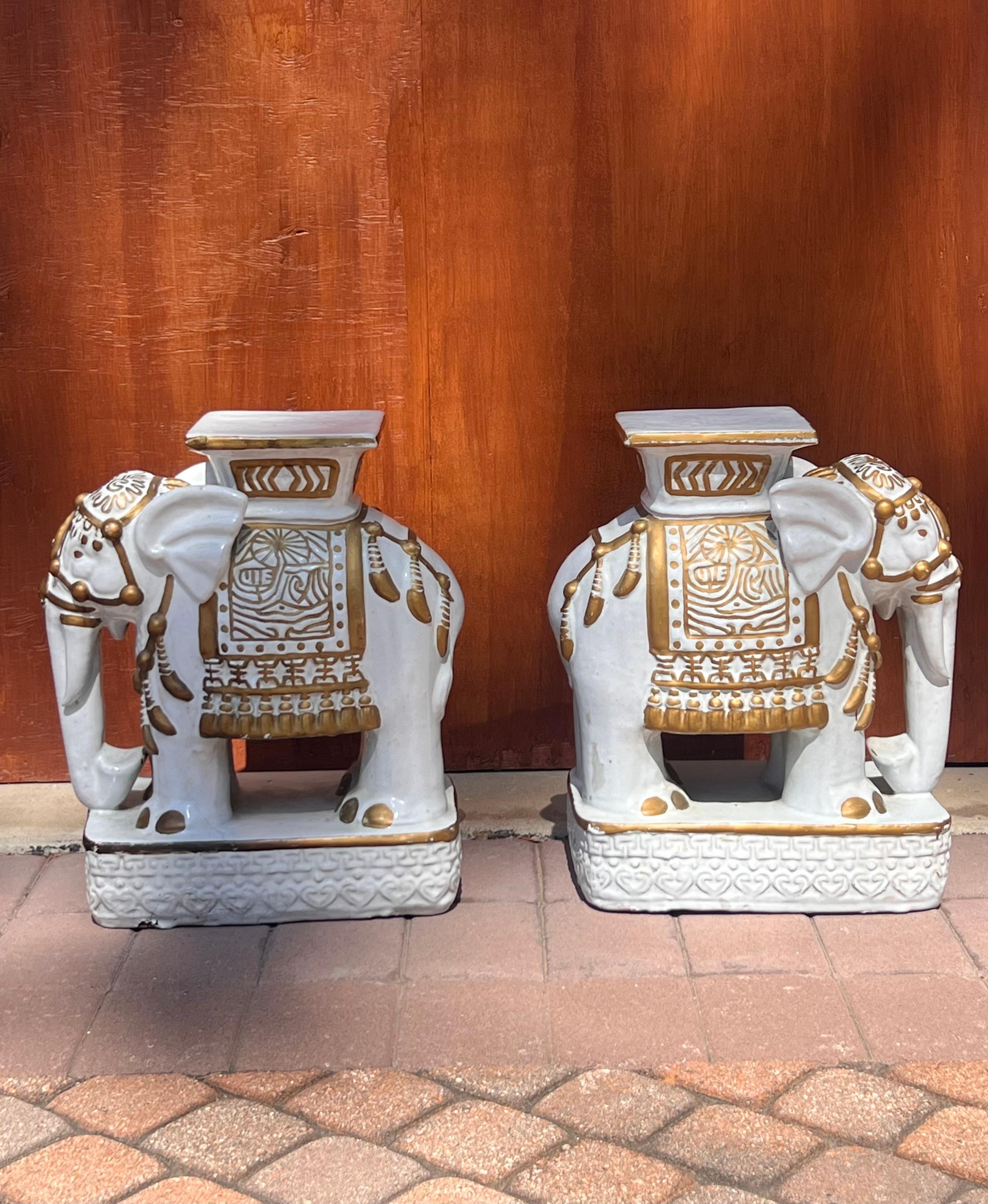 Paire de piédestaux bas en céramique représentant des éléphants asiatiques décorés, 20e siècle. Peints et vernis, dans des tons de neige et d'or. 