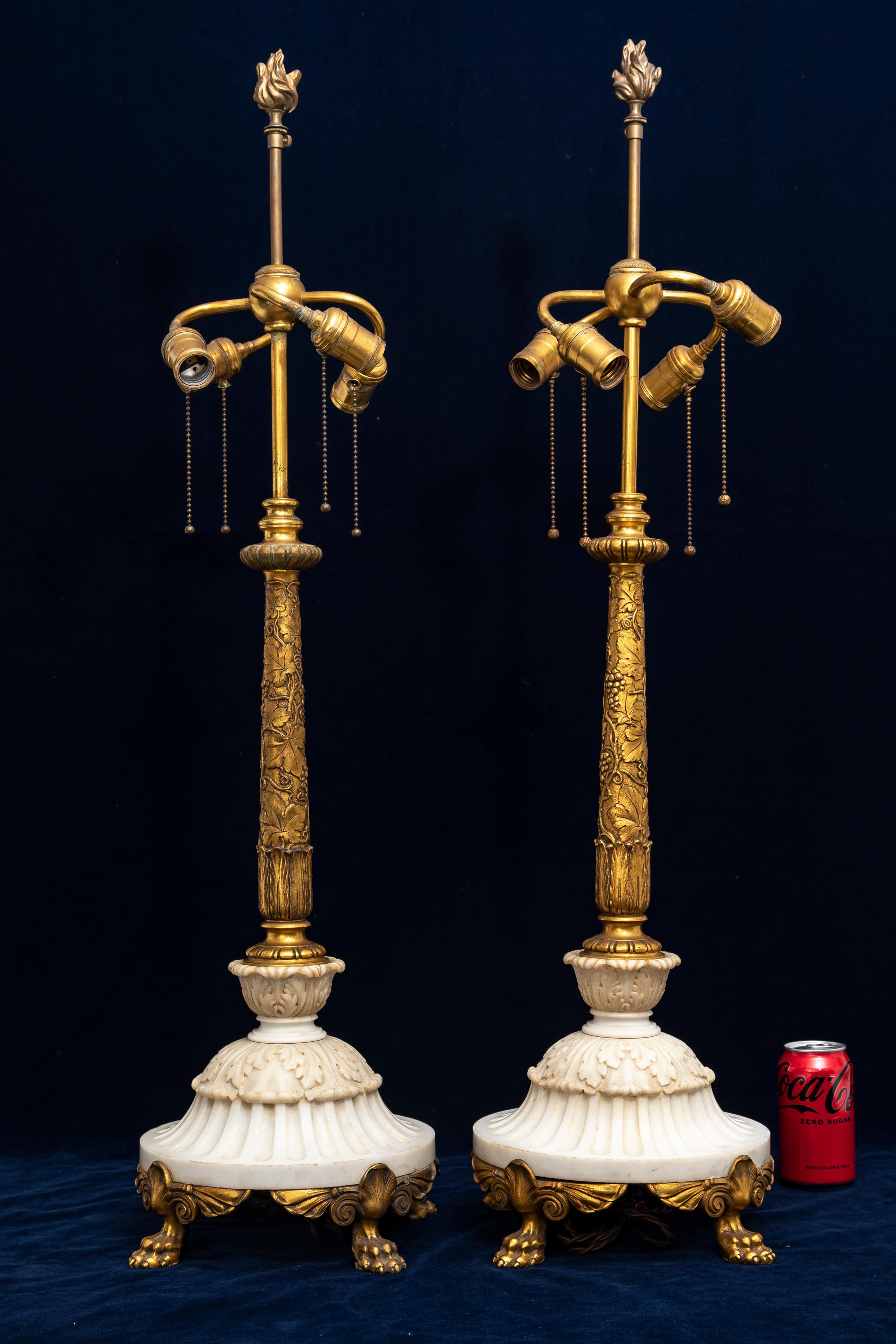 A Pair of Signed Sterling Bronze Co. New York. Ormolu and Carrara Marble Table Lamps, Attributed to E.F. Caldwell and Co.
Each lamp combines gilded bronze with hand-carved Carrara marble, showcasing classical design influences. The tapered ormolu