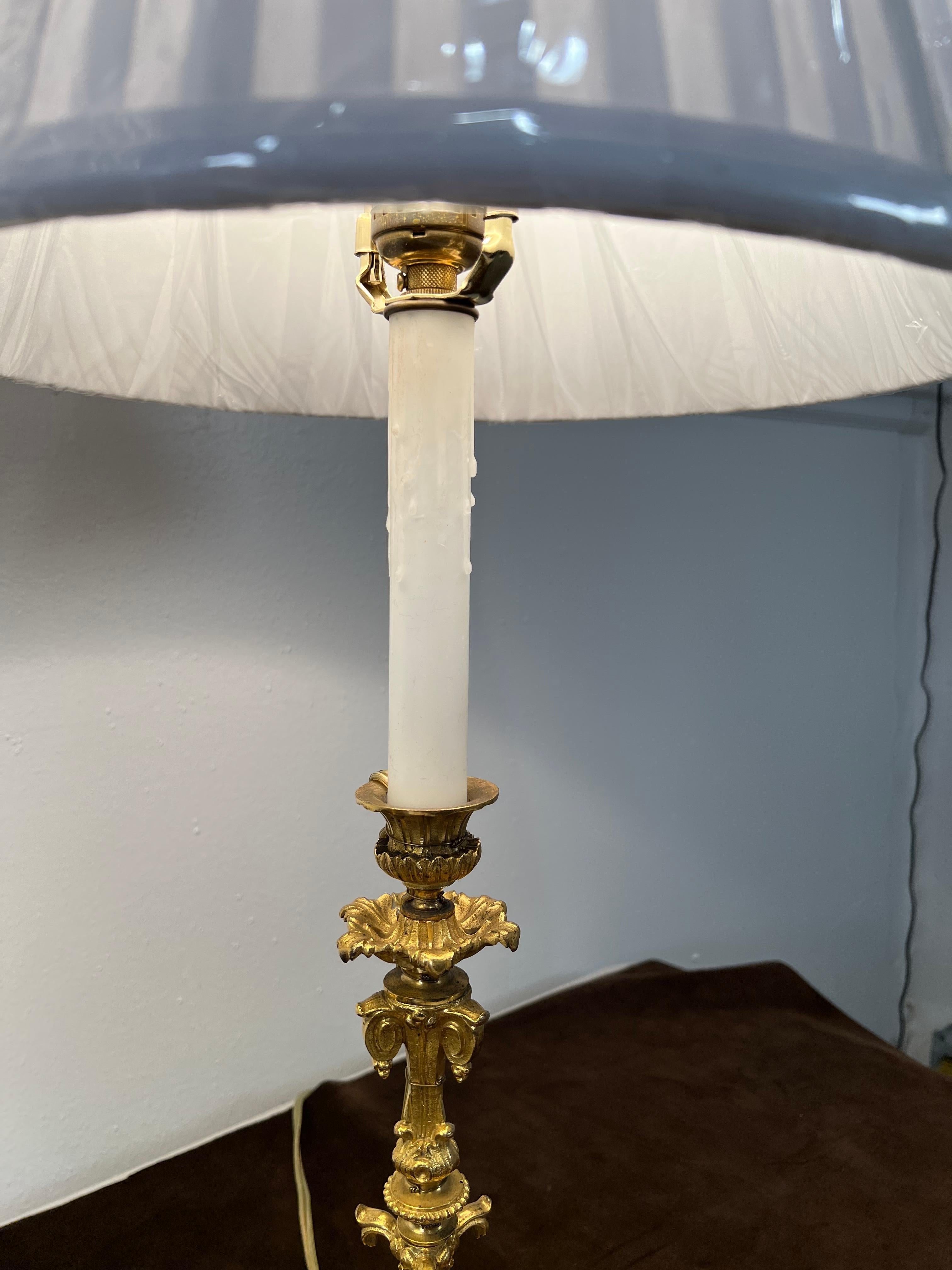 A pair of Ormolu candlestick form lamps, 19th century.
Wired & ready for use.
With 12 inch white silk pleated shades.
 