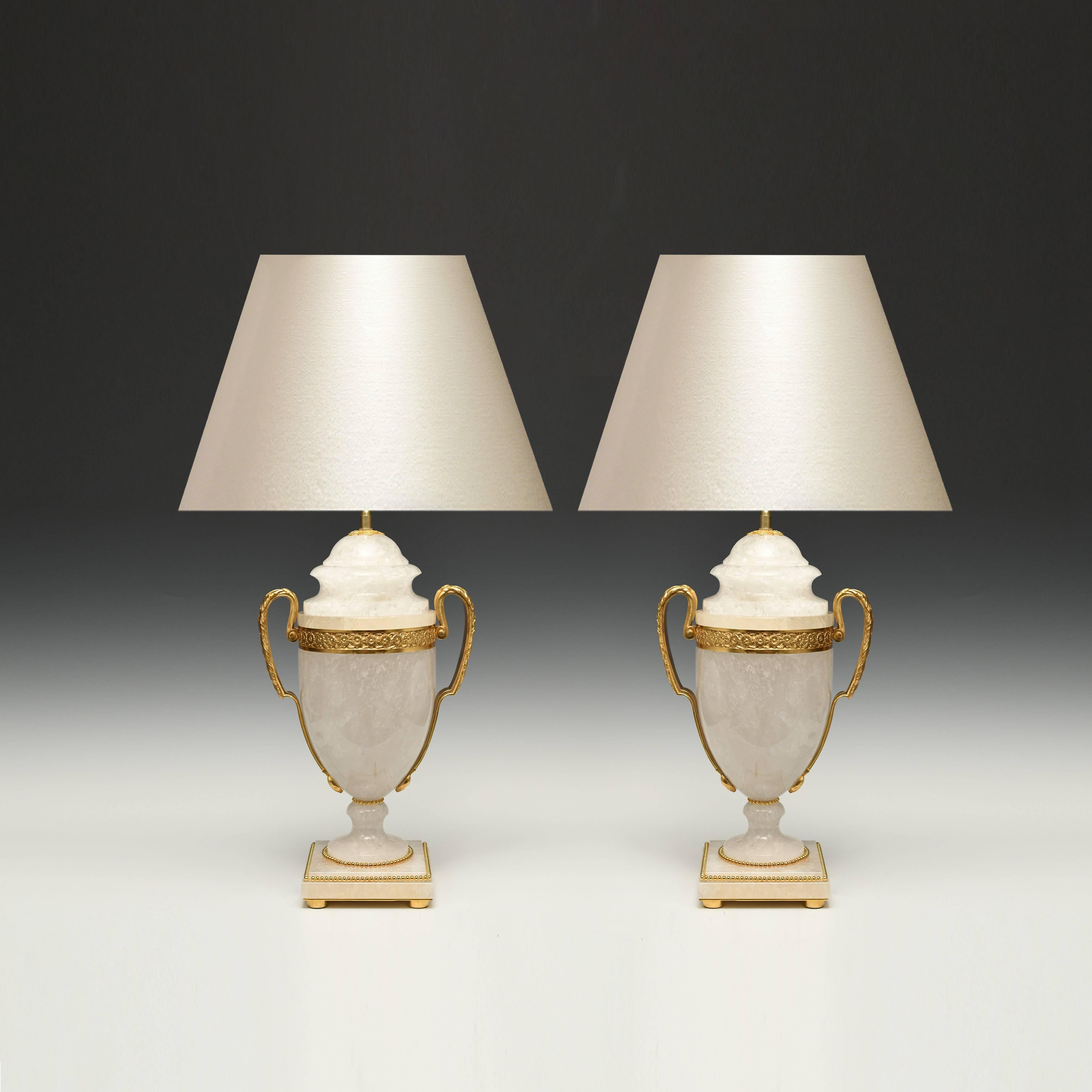 Une paire de lampes en cristal de roche en forme d'urne sculptée et montée en bronze doré. 
19 