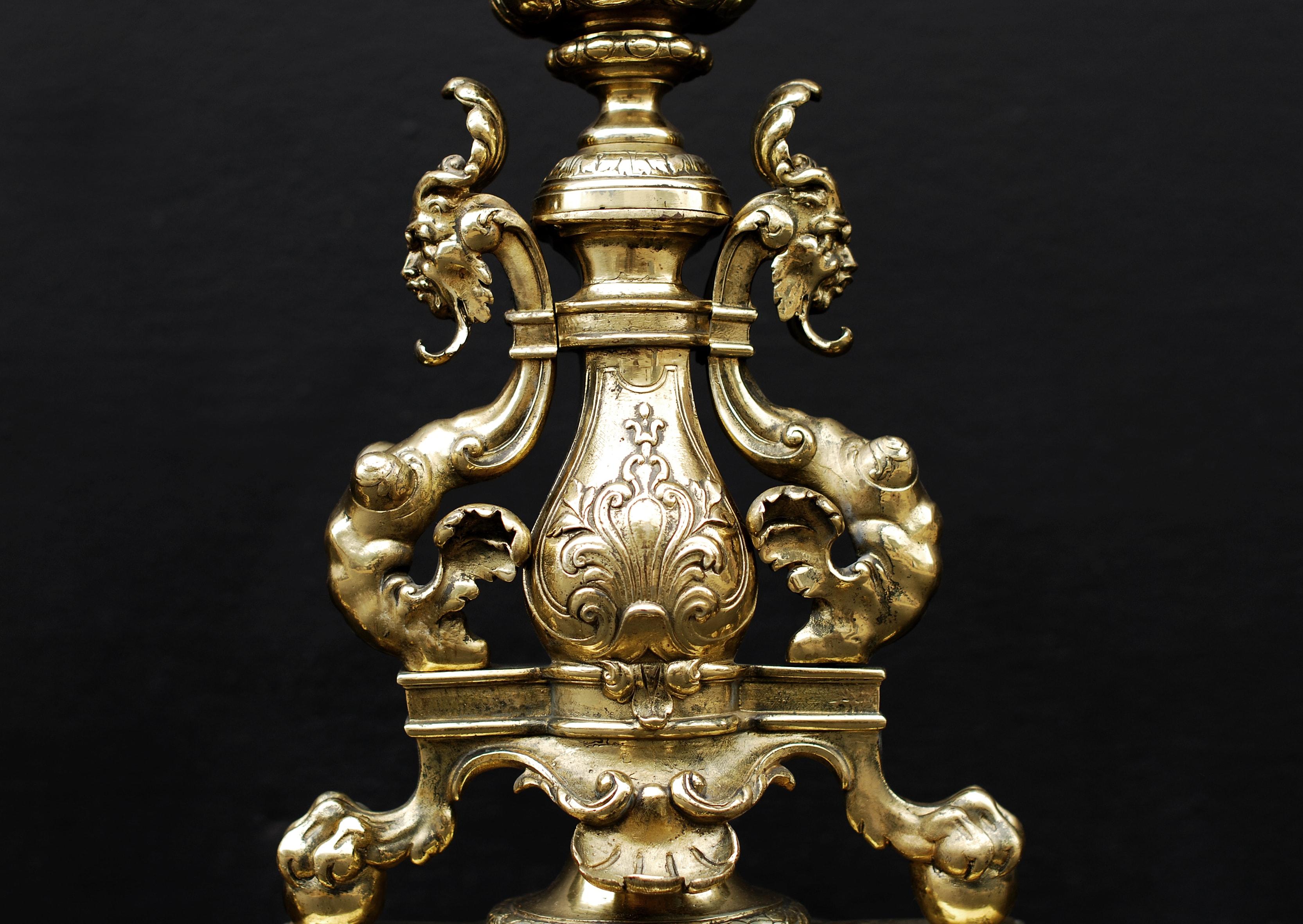A pair of ornate English, 19th century brass firedogs. The plinths with rope and knoll moulding surmounted by drapery festoon and claw and ball feet with masks and ornately cast finial of acorn and fruit. (Back bars could be added if