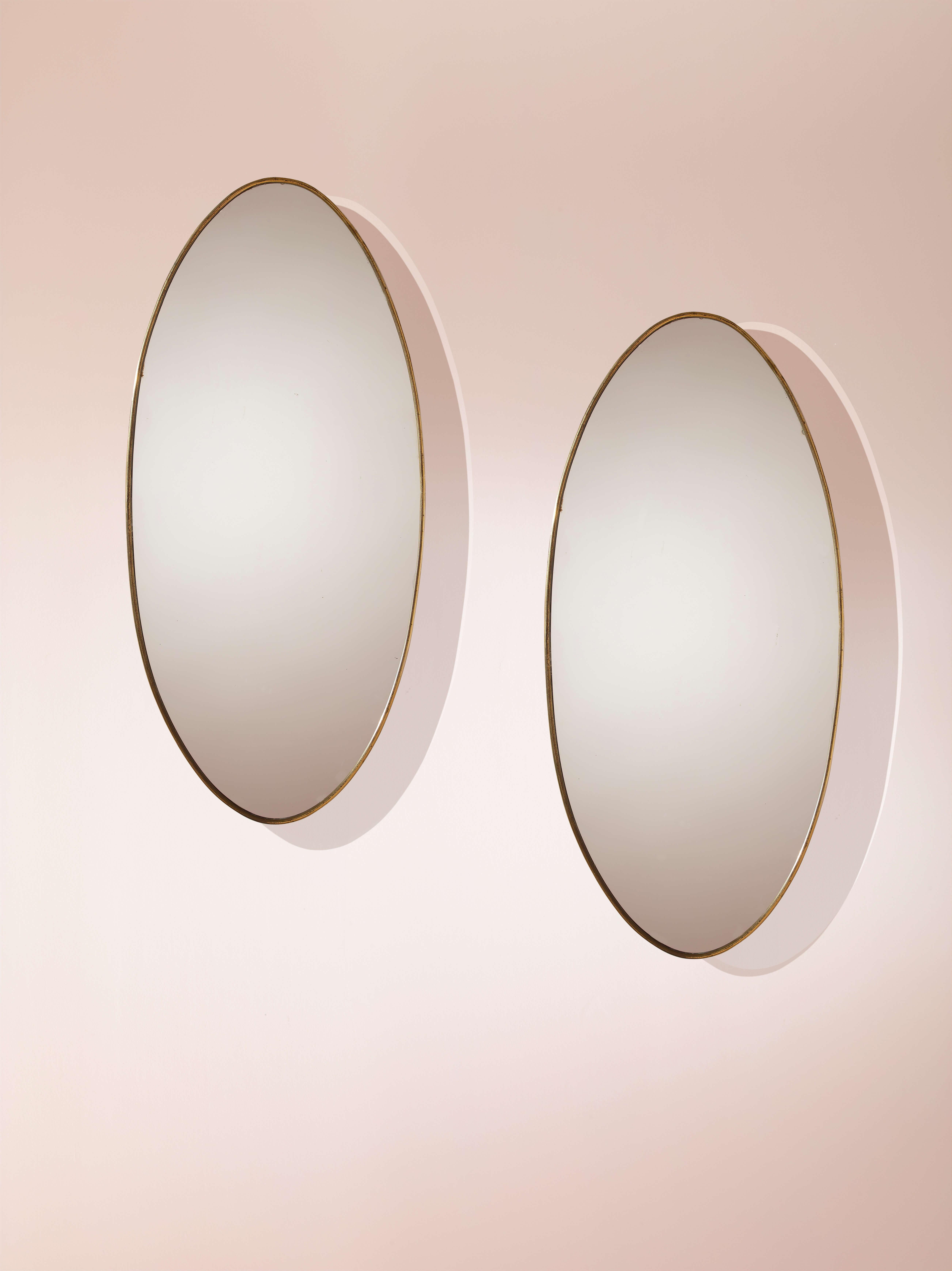 Une élégante paire de miroirs ovales avec des cadres en laiton, fabrication italienne, années 1960.

Deux ellipses élancées conçues pour être accrochées au mur, reflétant sur leurs surfaces polies ce qui se trouve devant elles. L'intégration de