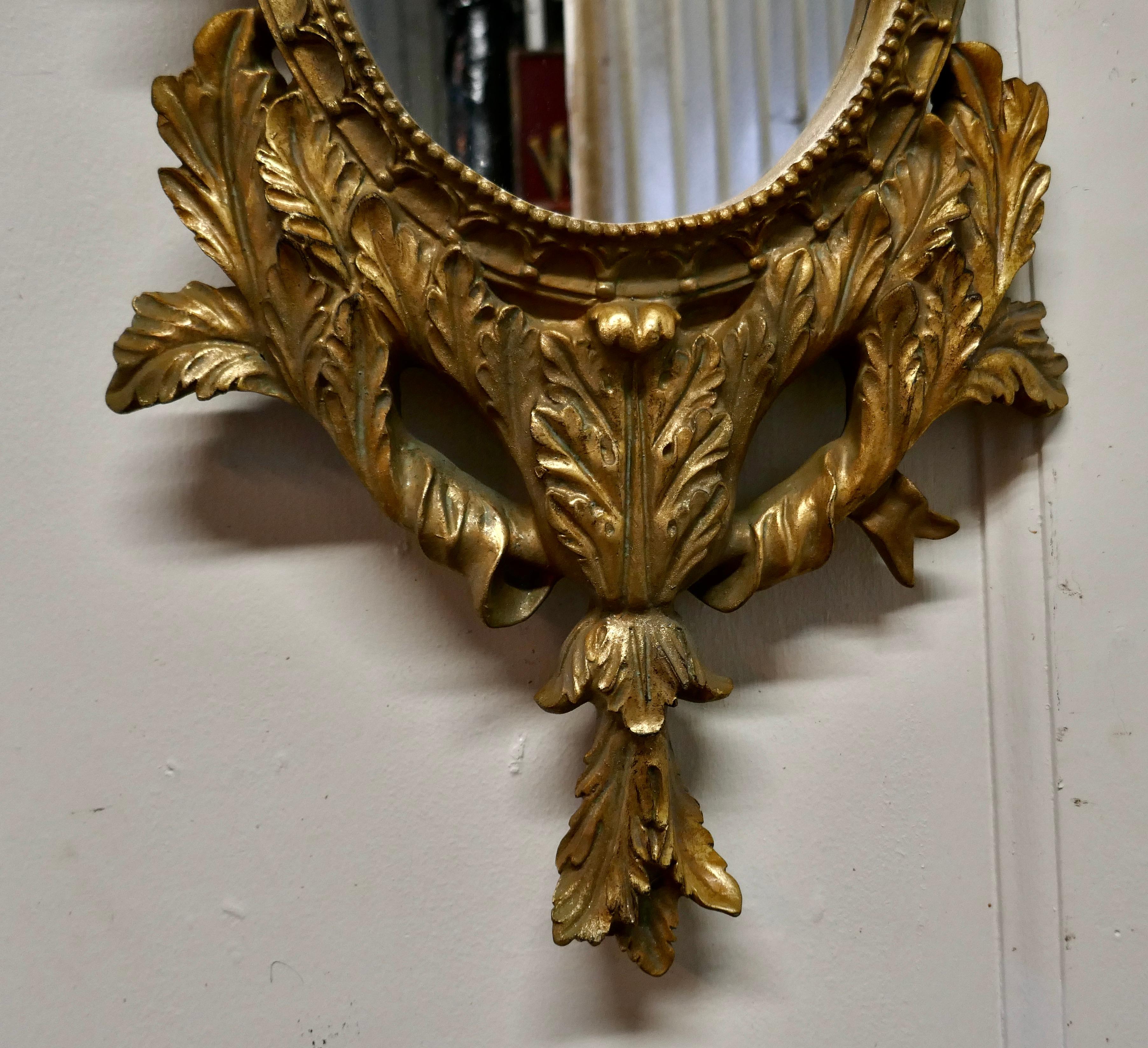 Feuille d'or Paire de miroirs muraux ovales rococo dorés en vente