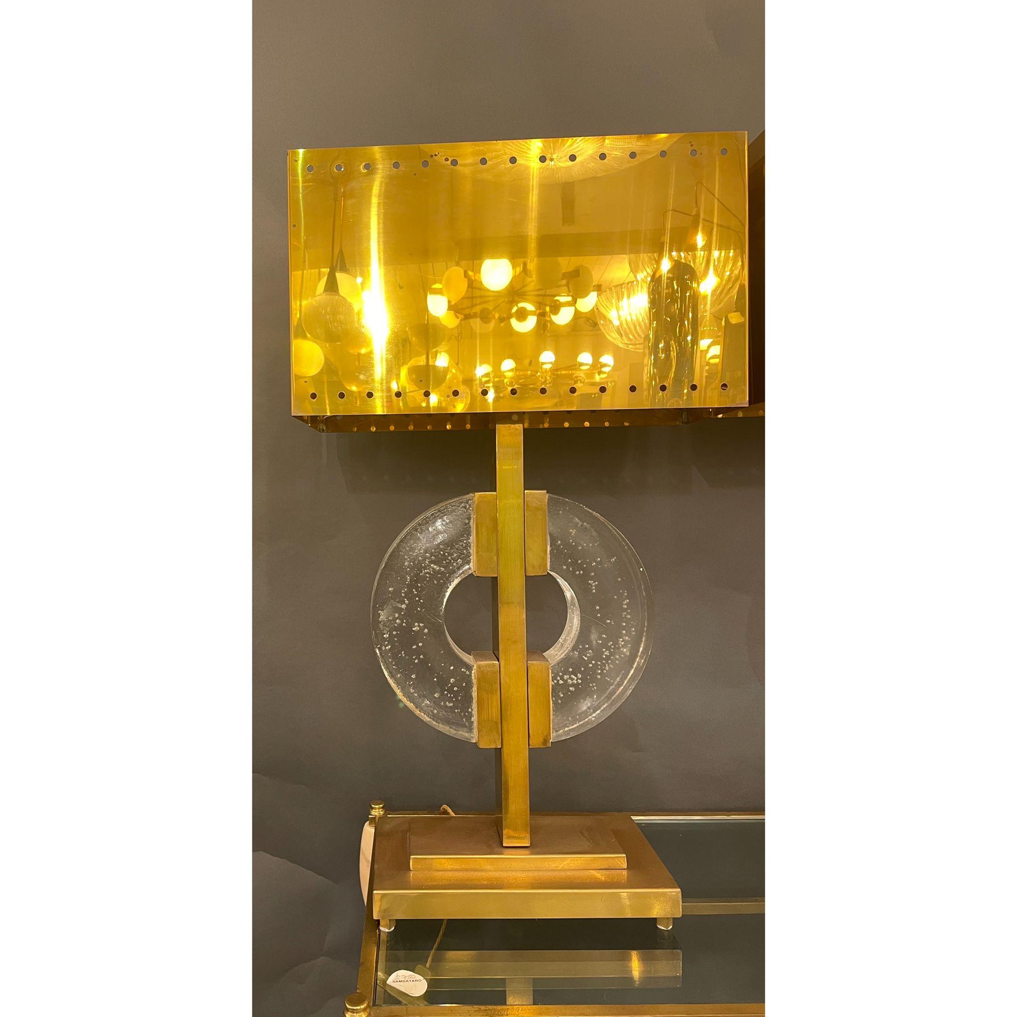 A particular pair of Italian table lamps with two half discs in Clear Murano Glass mounted to a stunning brass structure. It is a fantastic example of 1980s design.