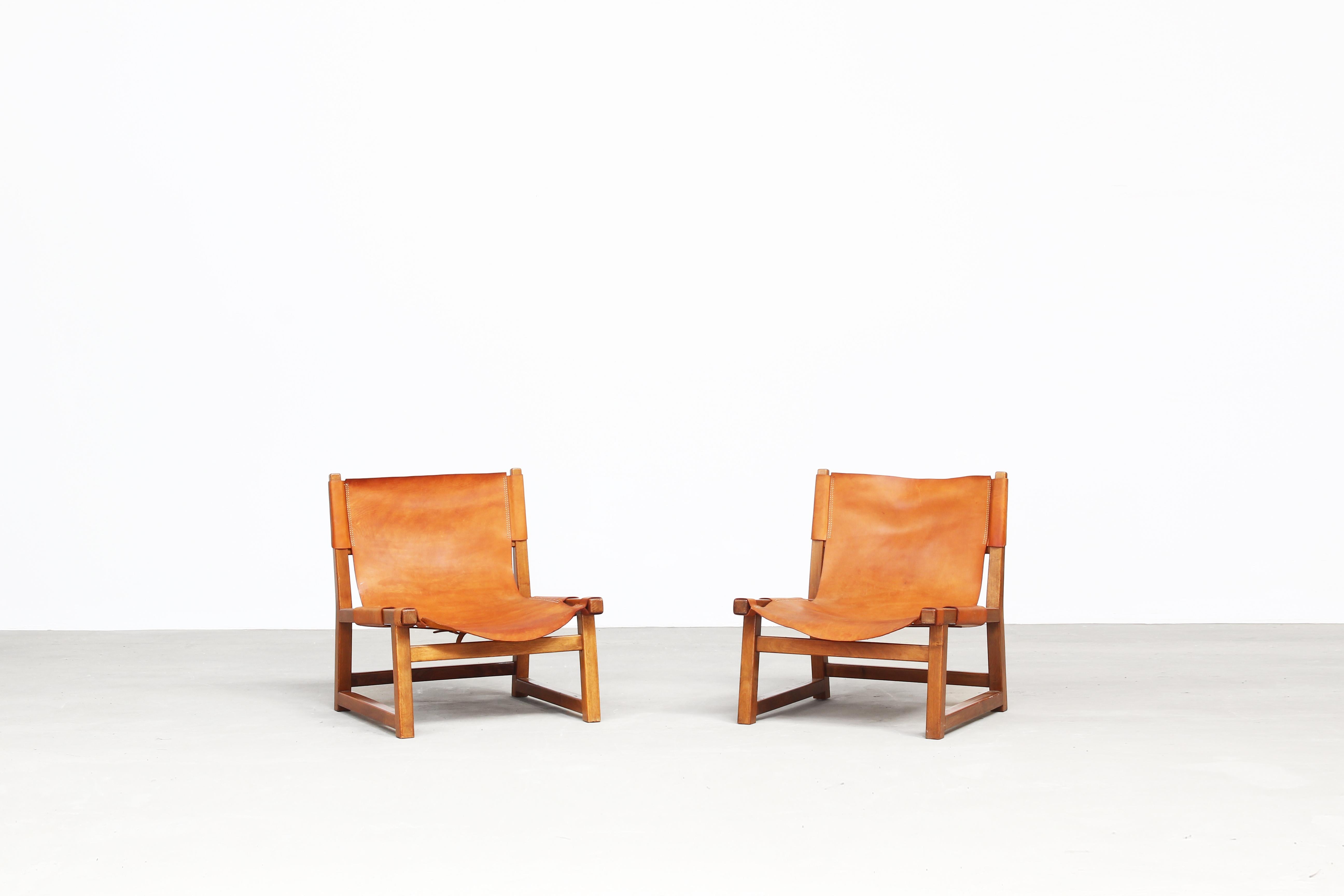 A beautiful pair of hunting chairs designed by Paco Muñoz for Darro, and well-known as 'Riaza' chair, Spain, 1960s.
Both chairs come in a great patinated leather and a wooden walnut frame, ready for usage.