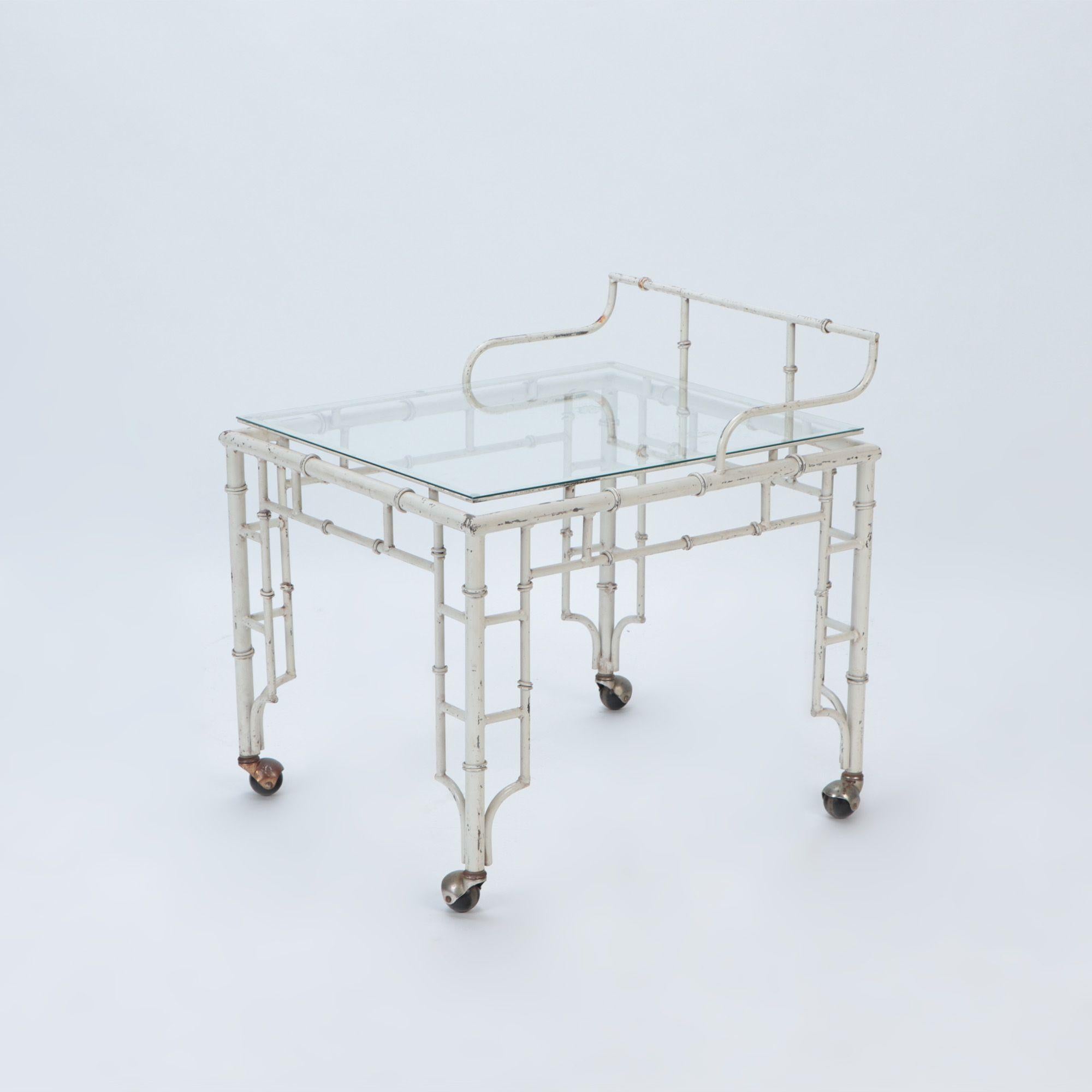 A pair of painted aluminum faux bamboo and glass bar carts, resting on four casters for easing mobility, circa 1970.