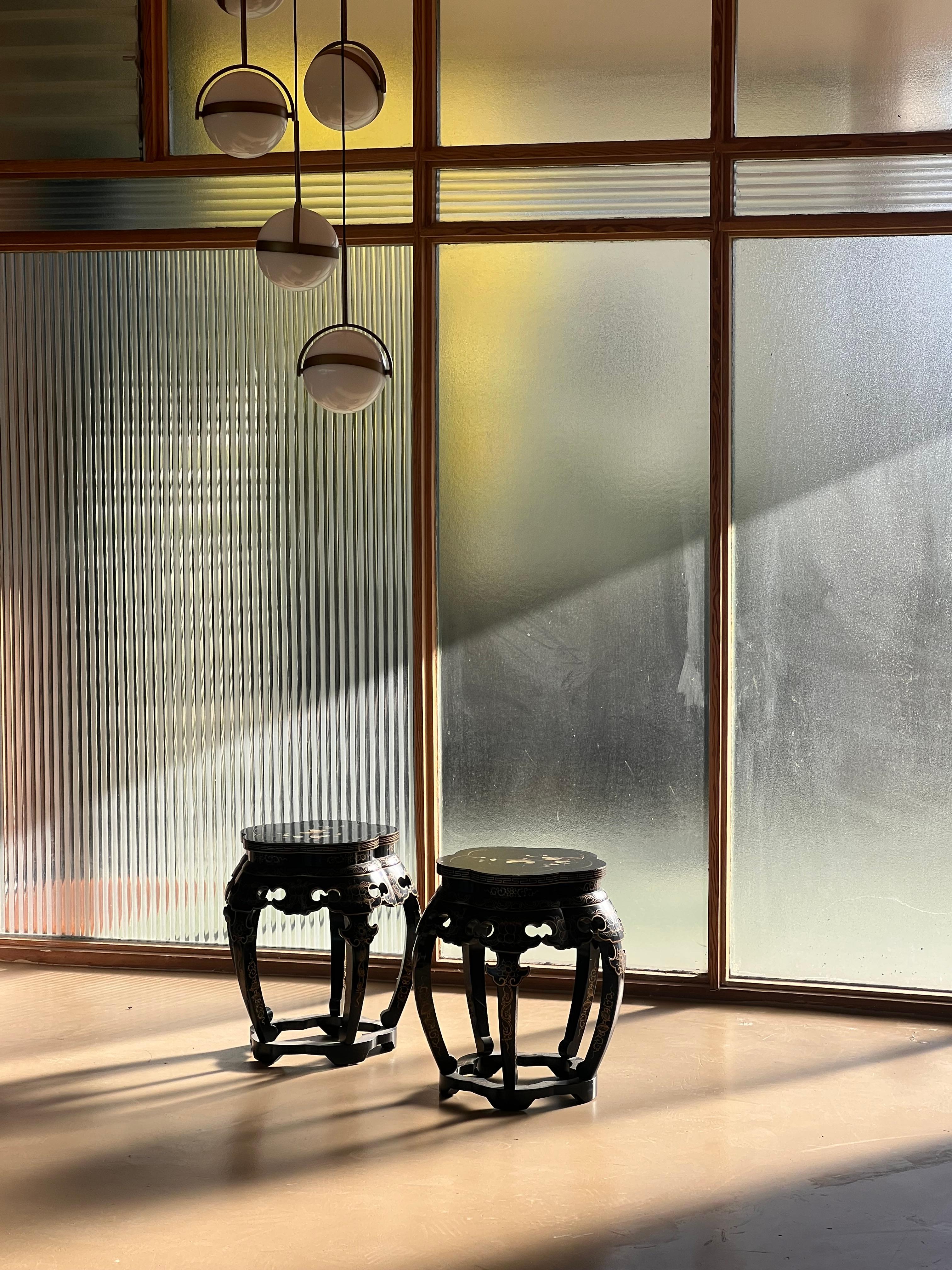 Ein Paar bemalte, stark geschnitzte und lackierte verzierte Chinoiserie-Hocker, Hongkong, Mitte 20. In tiefem Schwarz mit einem Motiv aus Blumen, Vögeln und asiatischer Ikonographie in Elfenbein-, Gold- und Nashornblautönen. Aus dem Nachlass eines