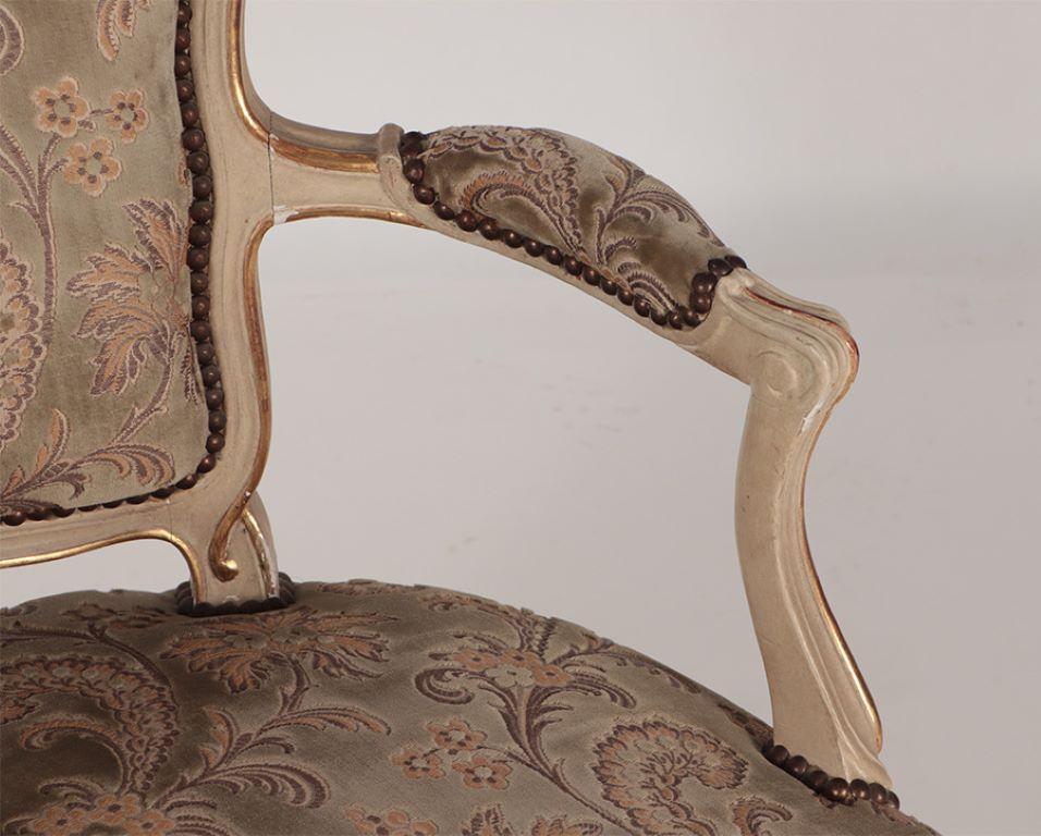 A pair of painted and giltwood French upholstered open armchairs Louis XV style In Good Condition For Sale In Philadelphia, PA