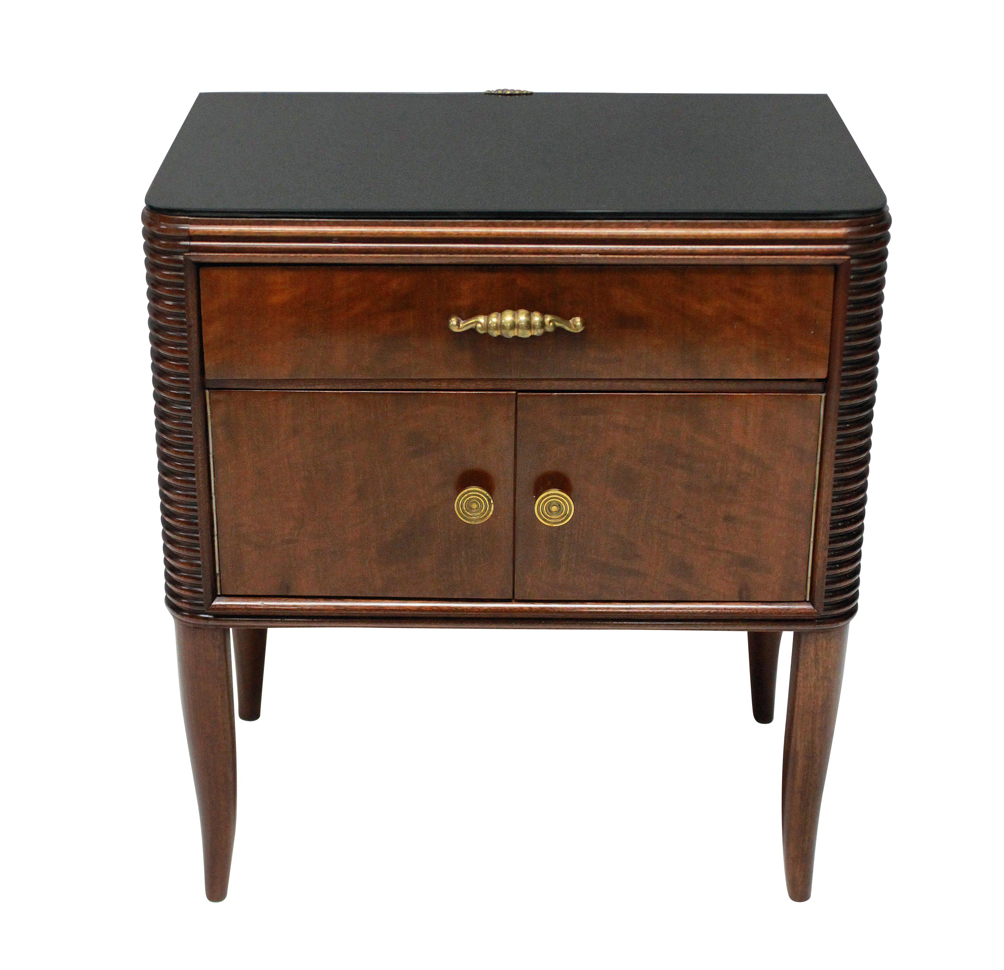 A pair of Italian night stands by Paolo Buffa in flame mahogany, comprising a cupboard and drawer above. On fine tapering legs, with black glass tops and nice detailing in the brass work.