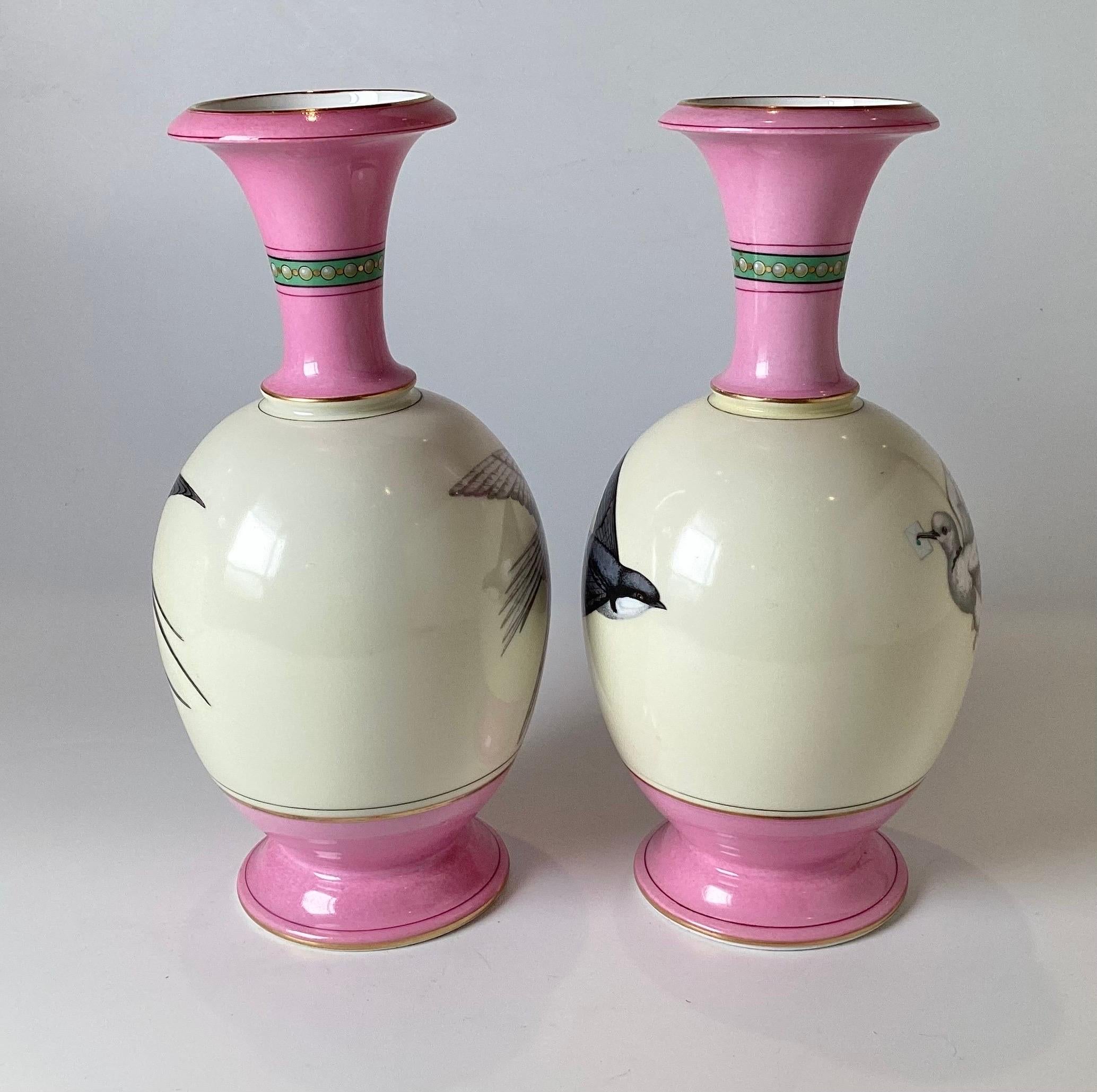 A wonderful pair of French porcelain hand painted vases.  The pair with hand painted black sparrows on one side, facing each other and the other side white doves.  The body in the shape of an egg in a soft ecru color with pink tops and bases. 