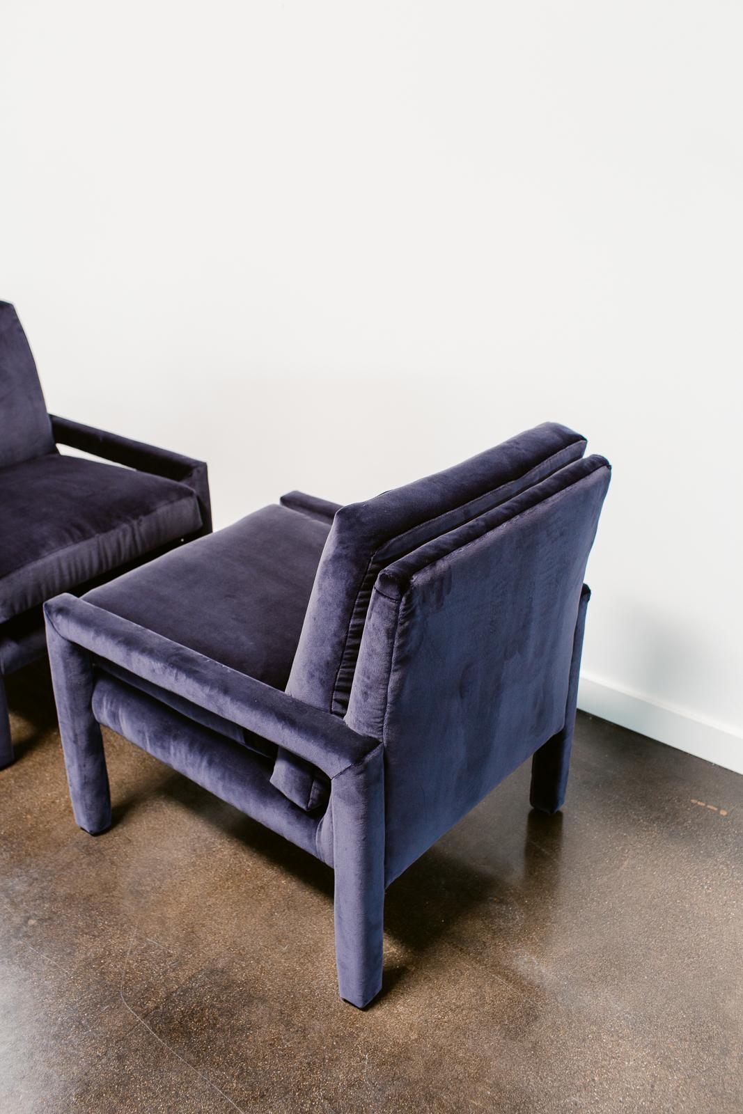 A pair of Milo Baughman Parson chairs reupholstered in a Holly Hunt velvet and restored with new high density foam cushions. These fully upholstered vintage armchairs are elegantly simple in line yet comfortable and functional. 

About Milo