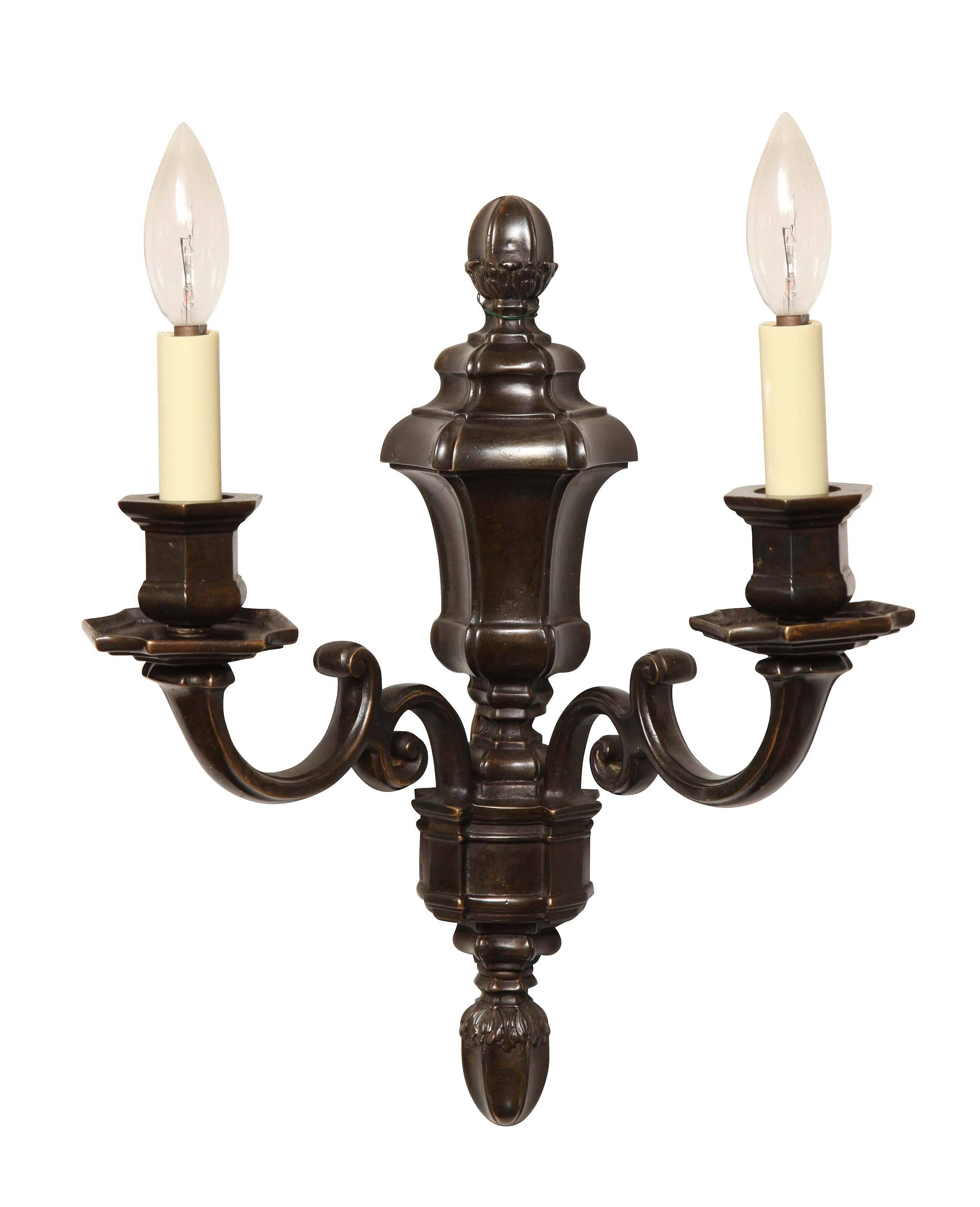 A pair of Dutch style, two-light patinated-bronze sconces by Edward F. Caldwell & Co, New York.