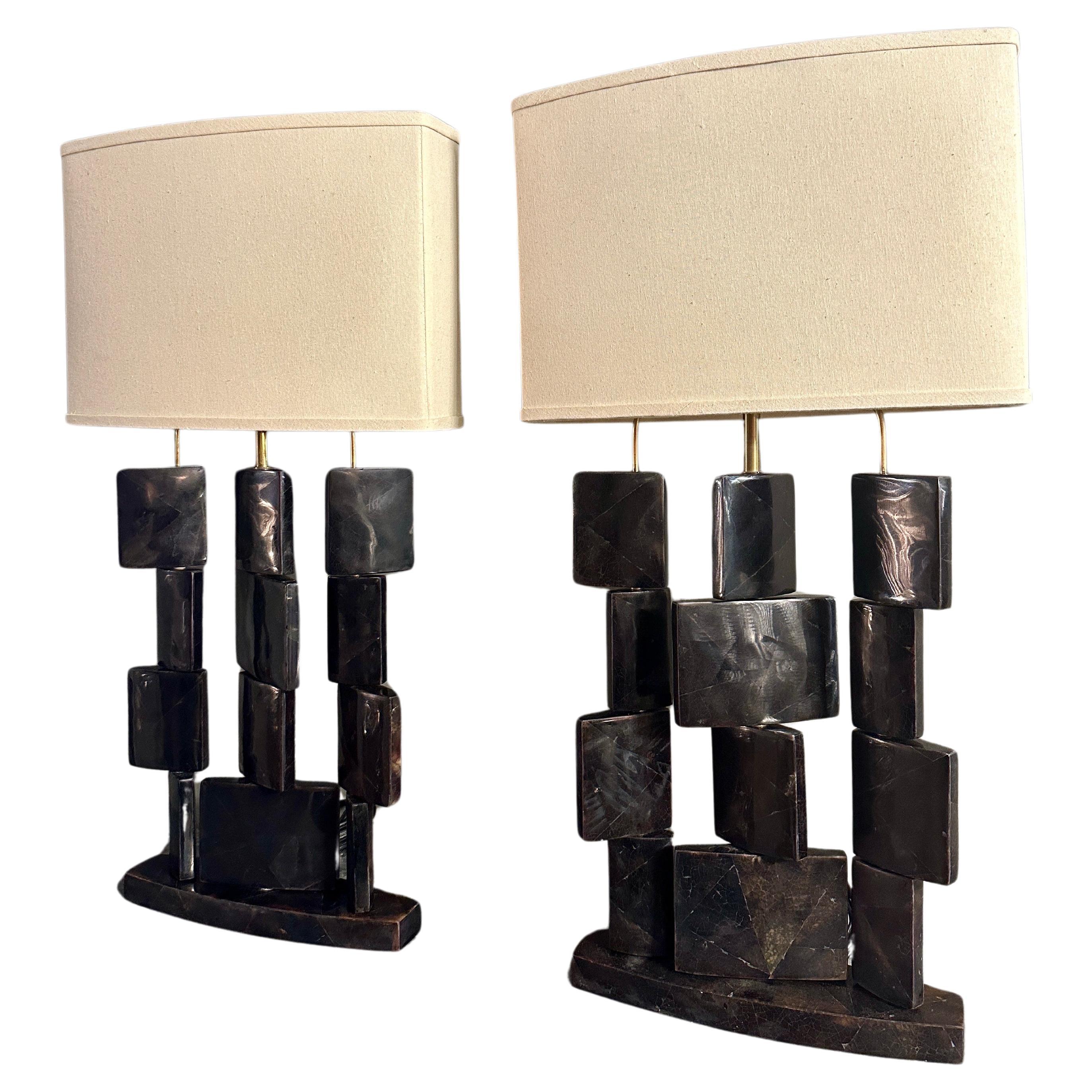 A Pair of  Pen shell and brass table lamps by R&Y Augousti Paris, with stacked movable geometric shaped pieces on brass supports and stood on oval shaped bases. Original linen covered hard backed shades. Augousti renowned for their use of exotic