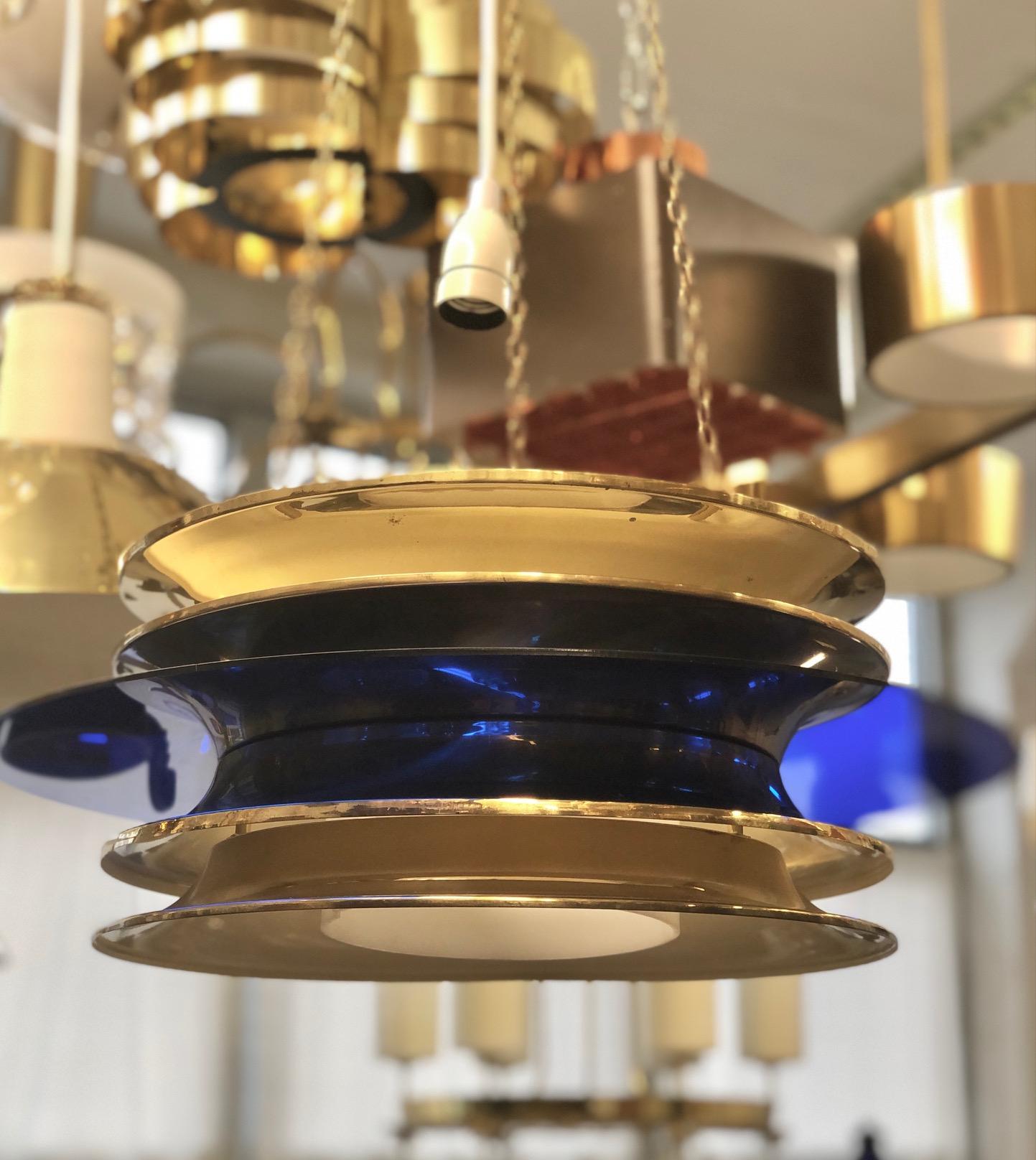 A pair of vintage pendants designed by Kai Ruokonen for Lynx, Finland, circa 1952.
Polished brass, blue acrylic disc and opaline acrylic diffuser.
Rewiring available upon request. Drop can be adjusted.
Can be sold separately, price is for each item.