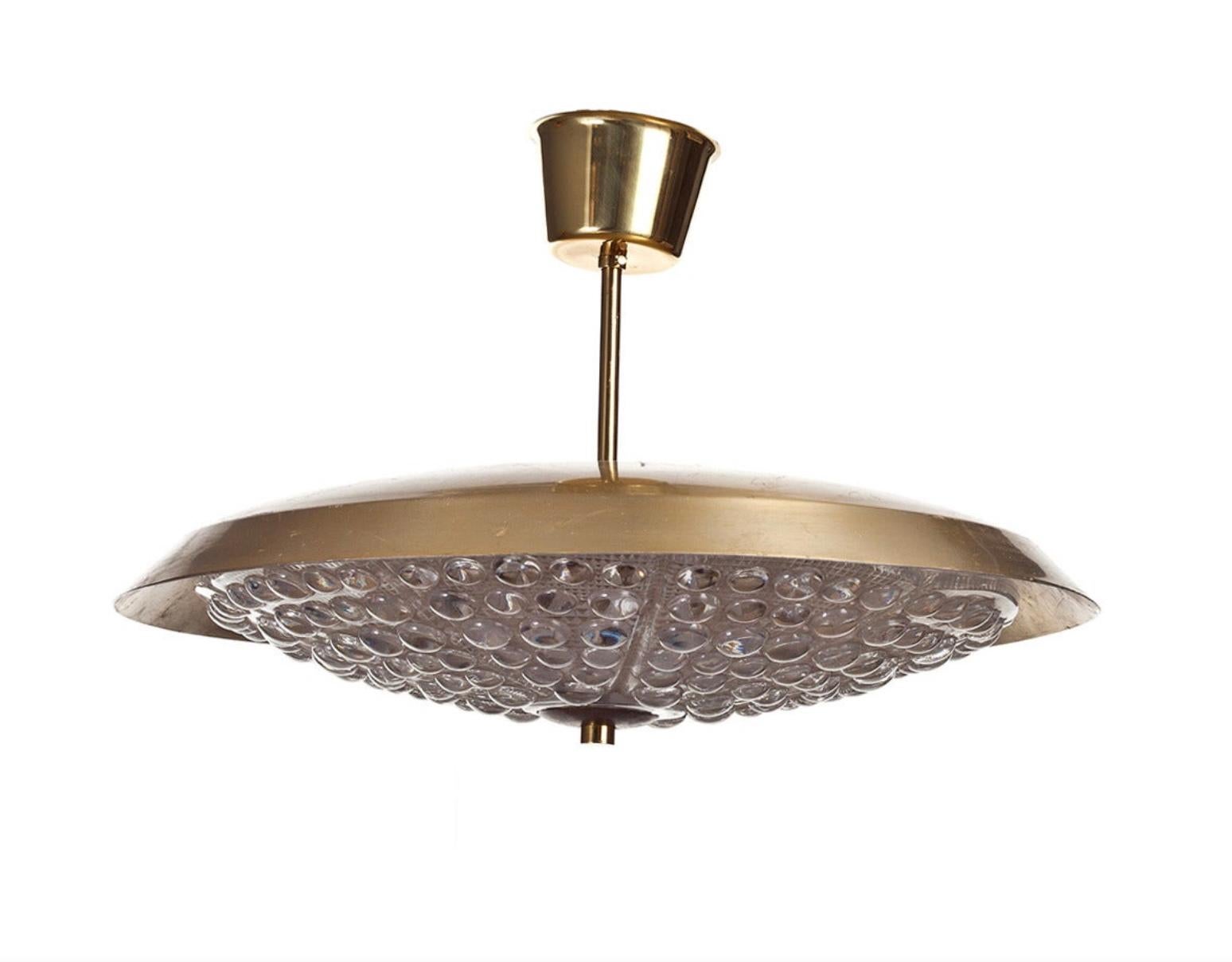 Coppia di lampadari vintage di Carl Fagerlund per Orrefors, Svezia, circa 1960. Vetro trasparente testurizzato e ottone. Misure: Diametro 48 cm. Cablaggio europeo esistente, ricablaggio disponibile su richiesta.