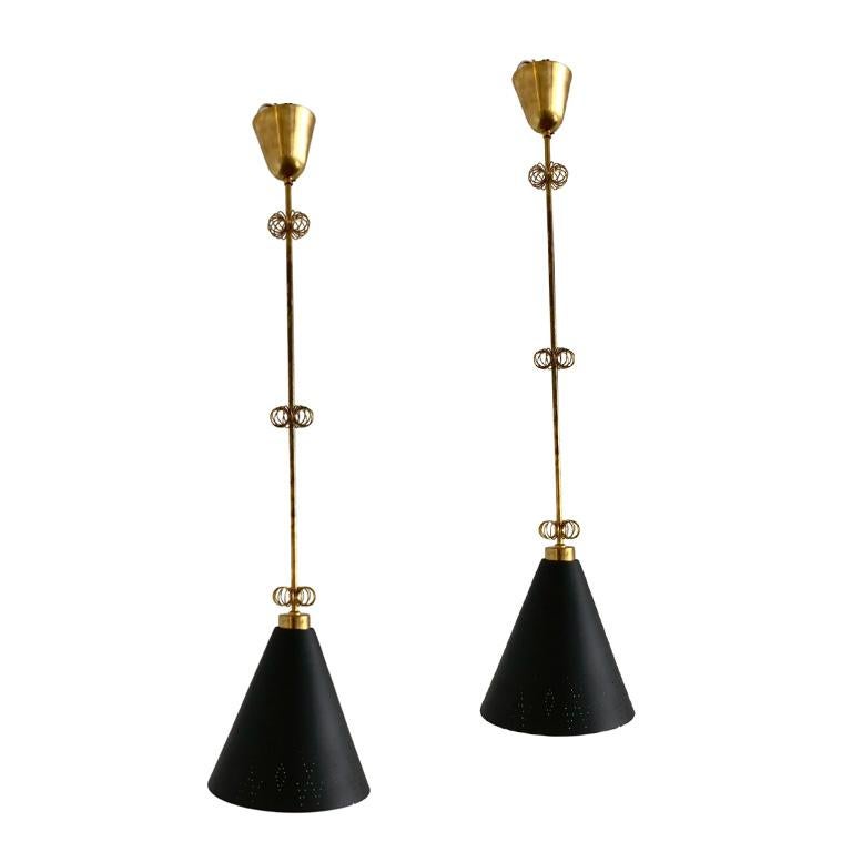 Coppia di ciondoli disegnati da Paavo Tynell, prodotti da Idman Oy, Finlandia, circa 1950. Paralume in metallo traforato, stelo in ottone lucido con decorazioni in filo d'ottone. Diametro 10