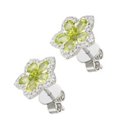 A pair of peridot and diamond flower cluster earrings