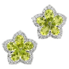 A pair of peridot and diamond flower cluster earrings