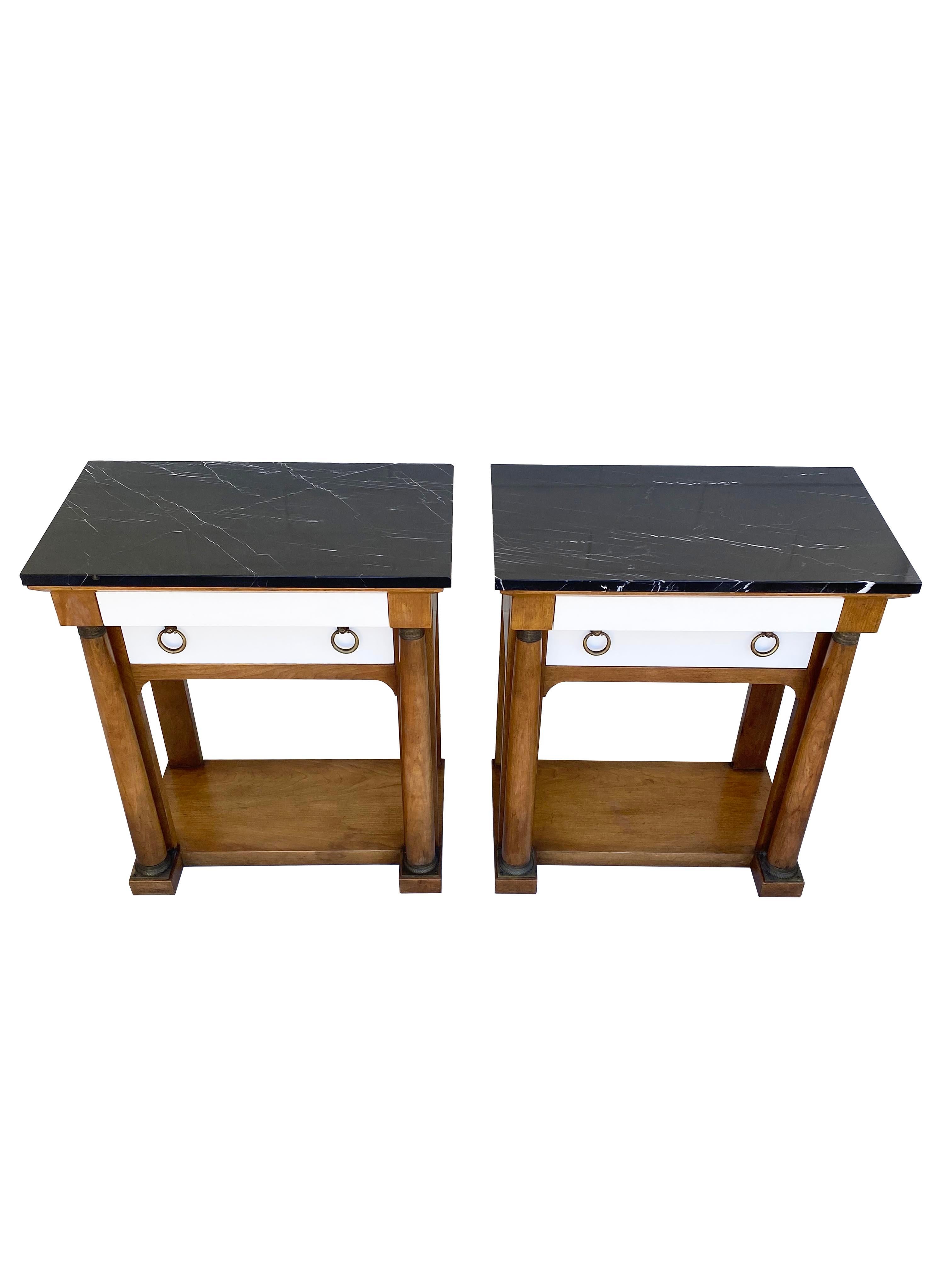 A masculine pair of Neoclassical nightstands or side tables by Baker Furniture! Clean lined silhouettes, with sculptured columns, marble tops, and aged brass accents. These vintage Baker chests were customized exclusively for THE TASTEMAKER SHOPPE.