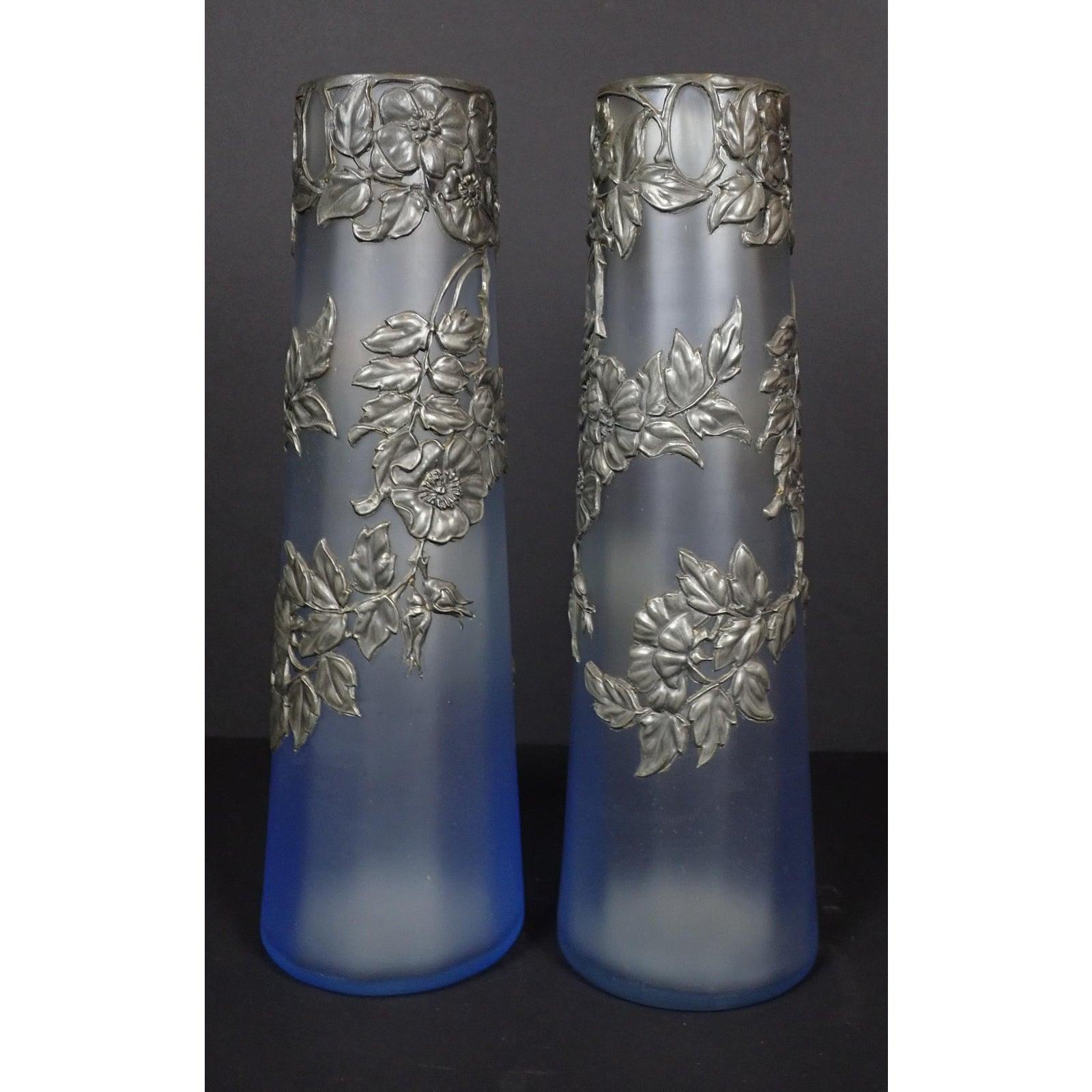 A pair of Pewter mounted opalescent glass vases. Pair of Art Nouveau style frosted pale blue opalescent art glass set with floral metal overlay.