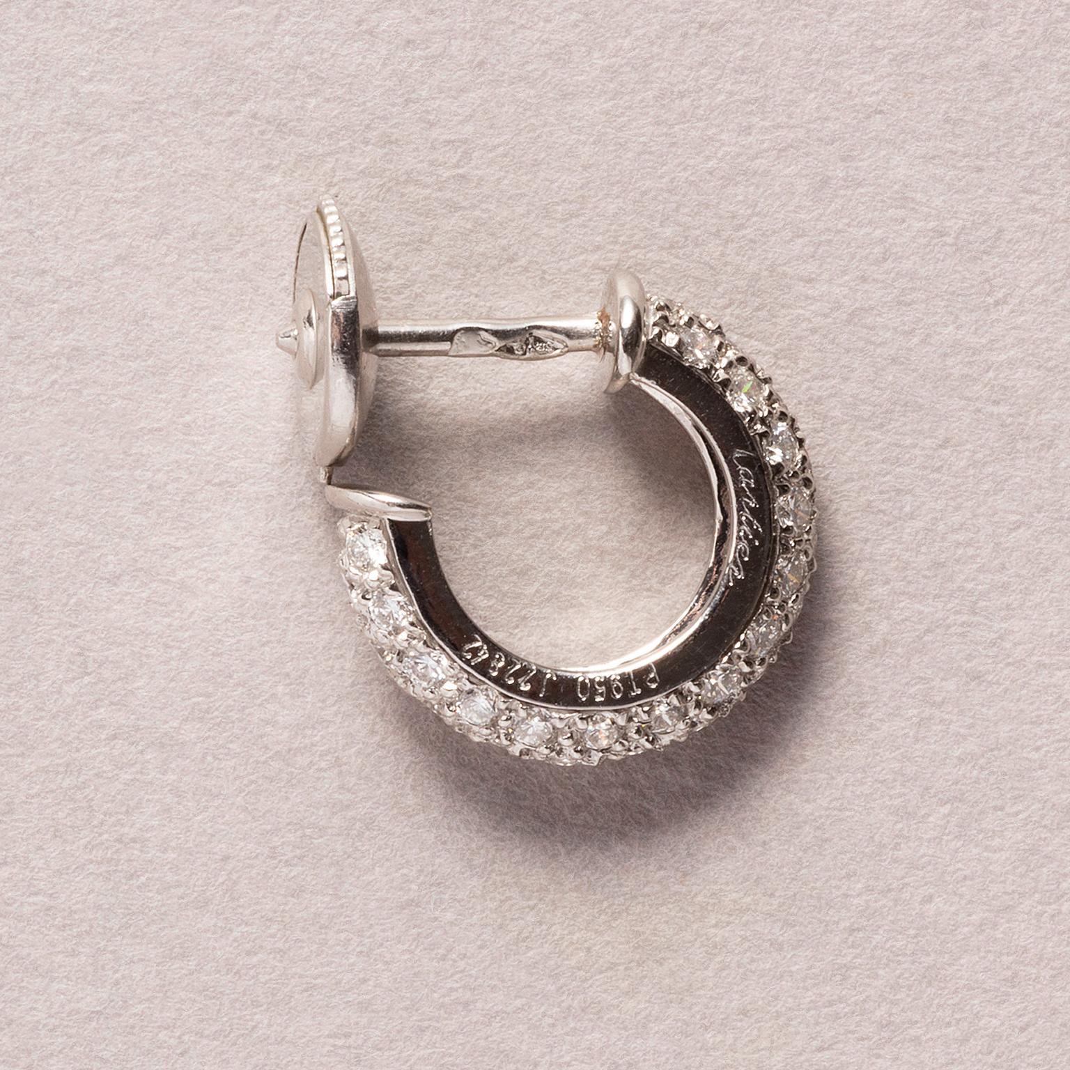 A pair of small platinum hoop or huggie earrings pavé set with brilliant cut diamonds (app. 0.96 carats). signed and numbered: Cartier, J422842, model Etincelle de Cartier, circa 1990.

weight: 5.14 grams
diameter: 13 mm
width: 0.4 mm