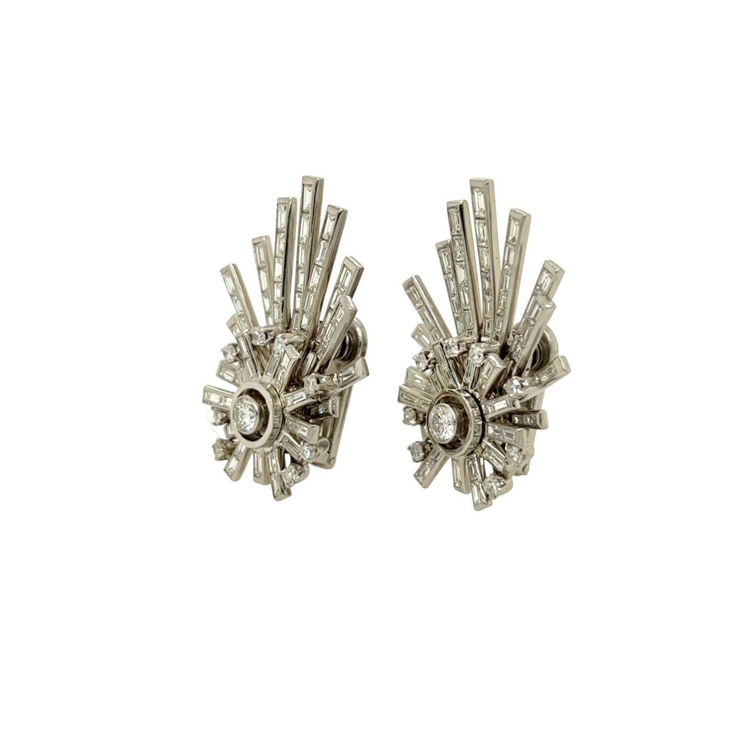 A pair of platinum and diamond earclips, circa 1950.  Each earclip designed as a starburst motif set with nine (9) round brilliant cut diamonds and eighteen (18) baguette cut diamonds surmounted by ascending rays set with an additional thirty six