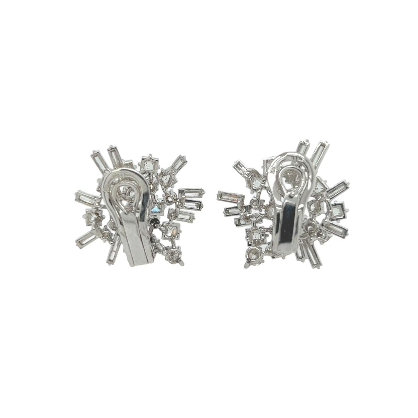 A pair of platinum and diamond earrings, French.  Each earring designed as a cluster with an extending spray set with ten (10) baguette cut diamonds, nine (9) round brilliant cut diamonds and eight (8) French cut diamonds, with 18 karat white gold