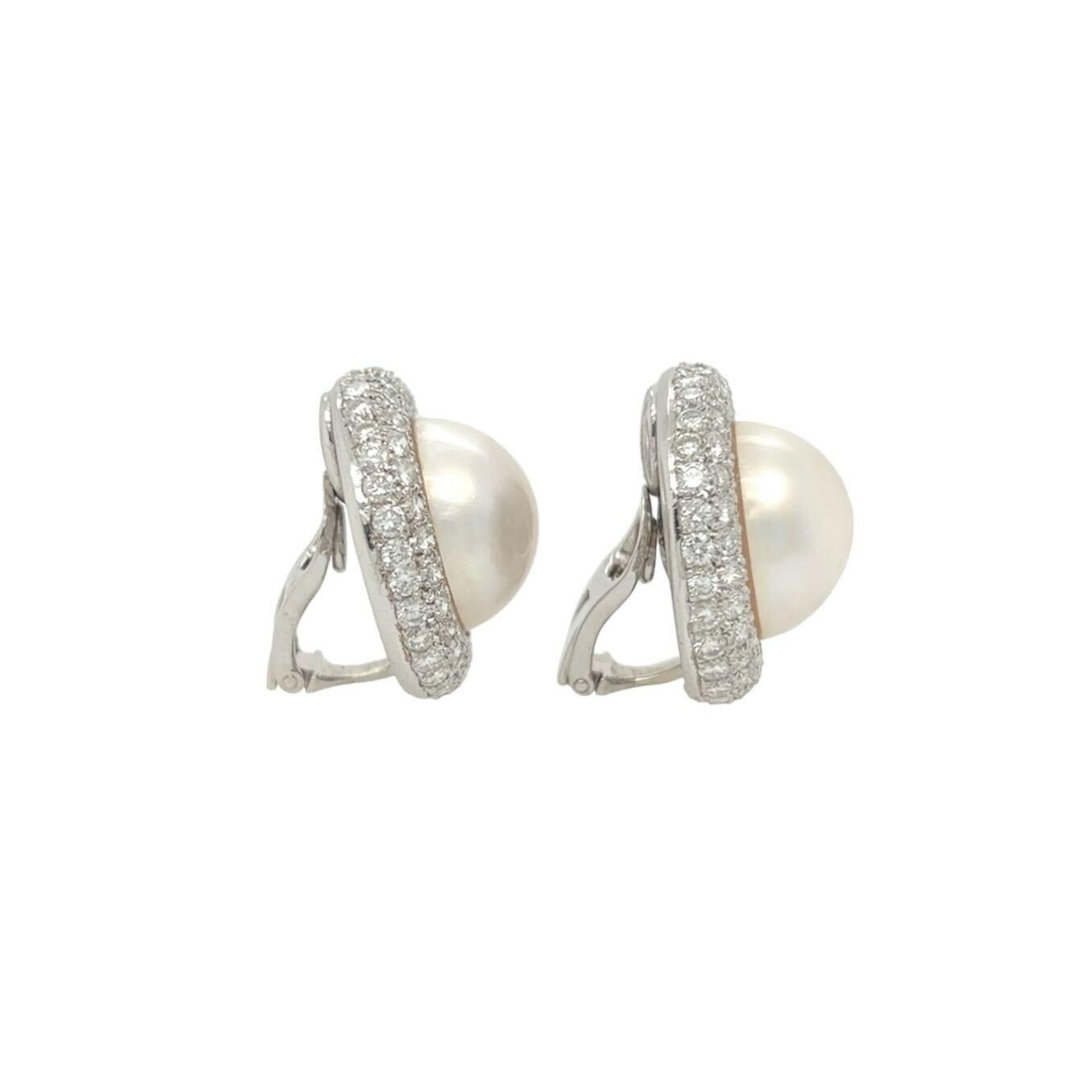 A pair of platinum, pearl and diamond earclips.  Each earclip centering a mabe pearl measuring approximately 16.4 mm within a convex circular frame pave set with approximately eighty six round brilliant cut diamonds.  Total diamond weight