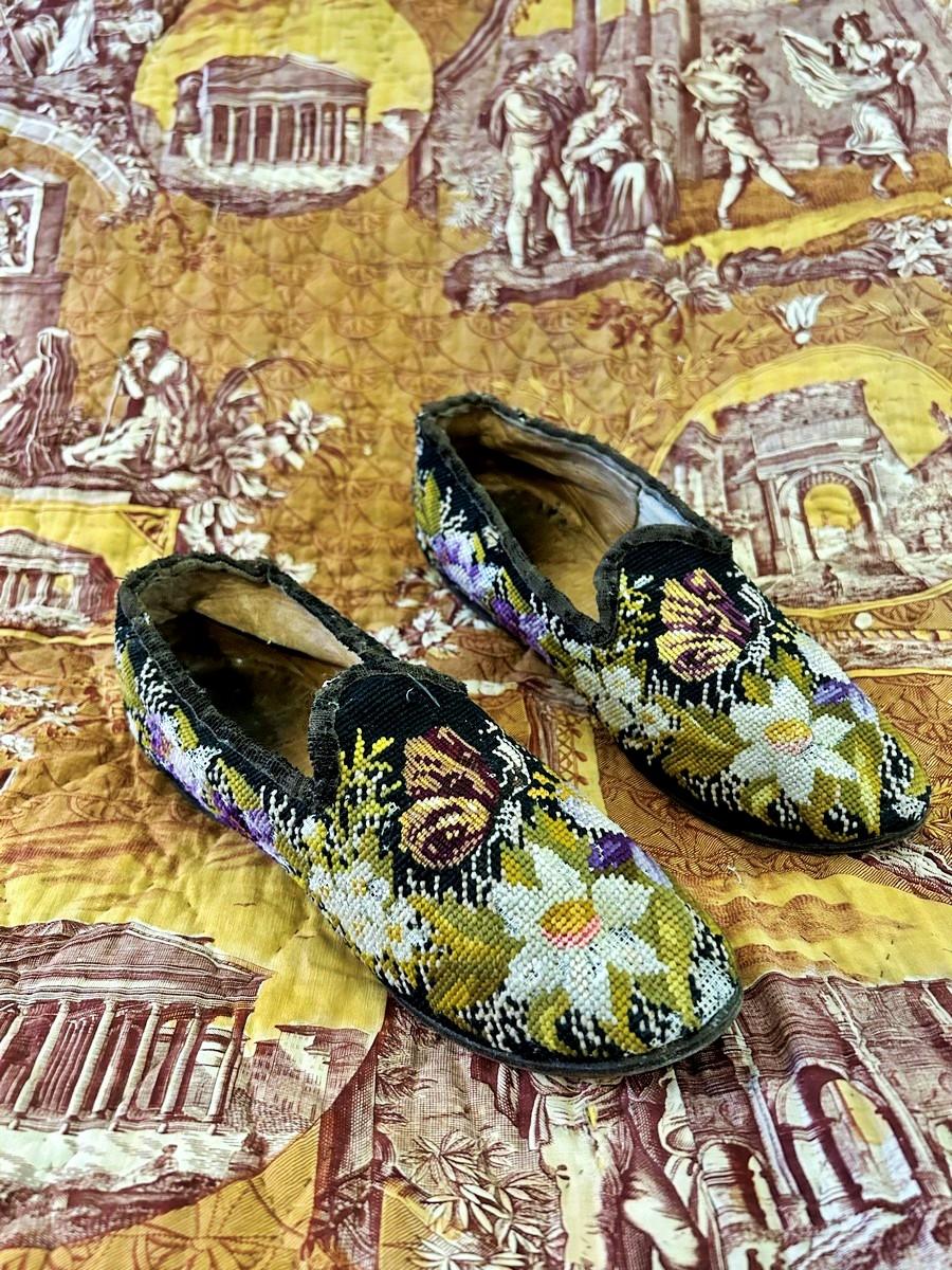 Circa 1860-1880
France

Charming pair of men's slippers embroidered in wool in a very assertive Second Empire floral design! Cream cotton and leather lining, tan leather soles and heels finely studded.  Brown curly velvet ribbon piping applied