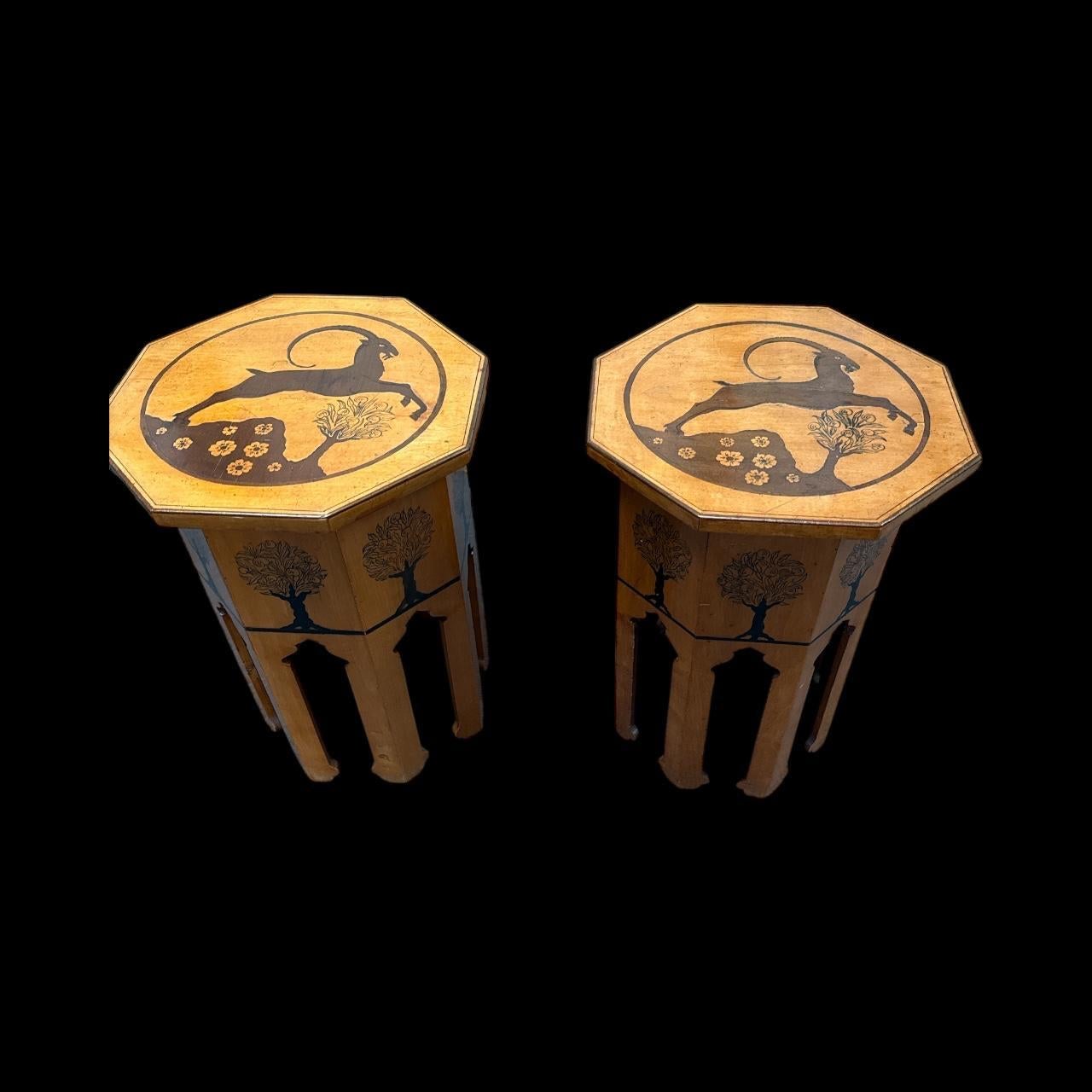 A Pair Of Poker Work And Inlaid Octagonal Side Tables
A Pair Of Poker Work And Inlaid Octagonal Side Tables Early 20th Century, In The Manner Of Liberty
The Tops Inlaid With A Leaping Antelope And The Sides Decorated With Apple Trees, Both In The