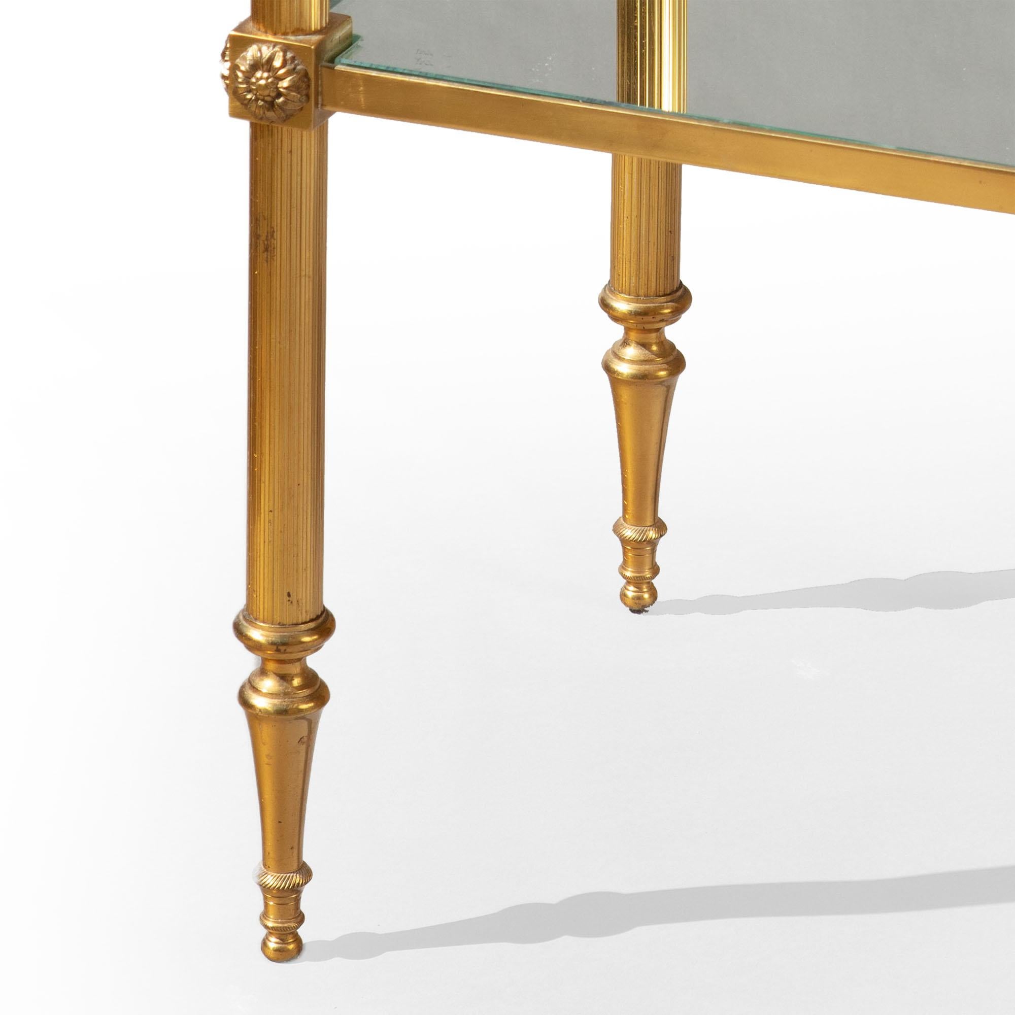 A pair of polished brass two-tier end tables with acorn finials, reeded legs and toupie feet, the two tiers with mirrored shelves.

France, circa 1970

Dimensions: Height 29.5