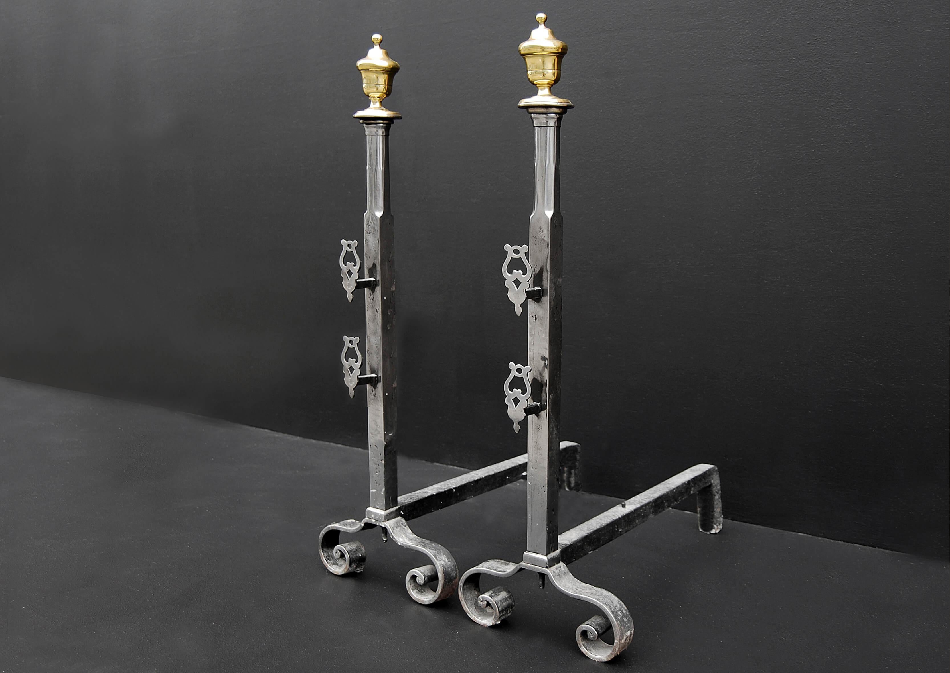 Pair of steel firedogs with brass urns to tops and spit holders to fronts.

Measures: Height: 785 mm 30 