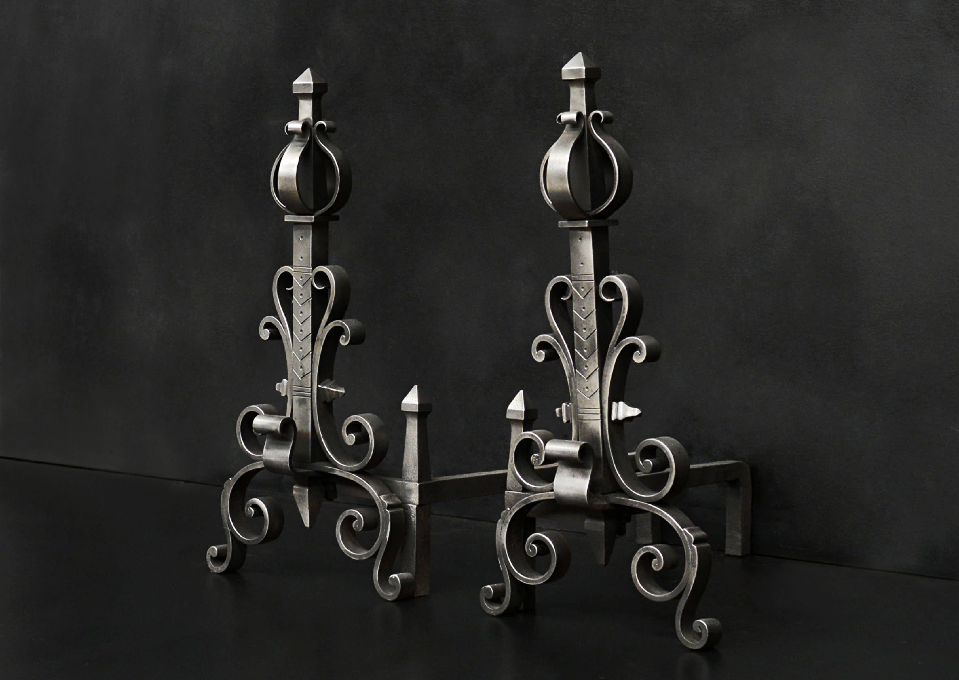 A pair of polished steel firedogs with scrollwork throughout and engraved shafts. English, late 19th/early 20th century.

Measures: Height: 570 mm 22 ½