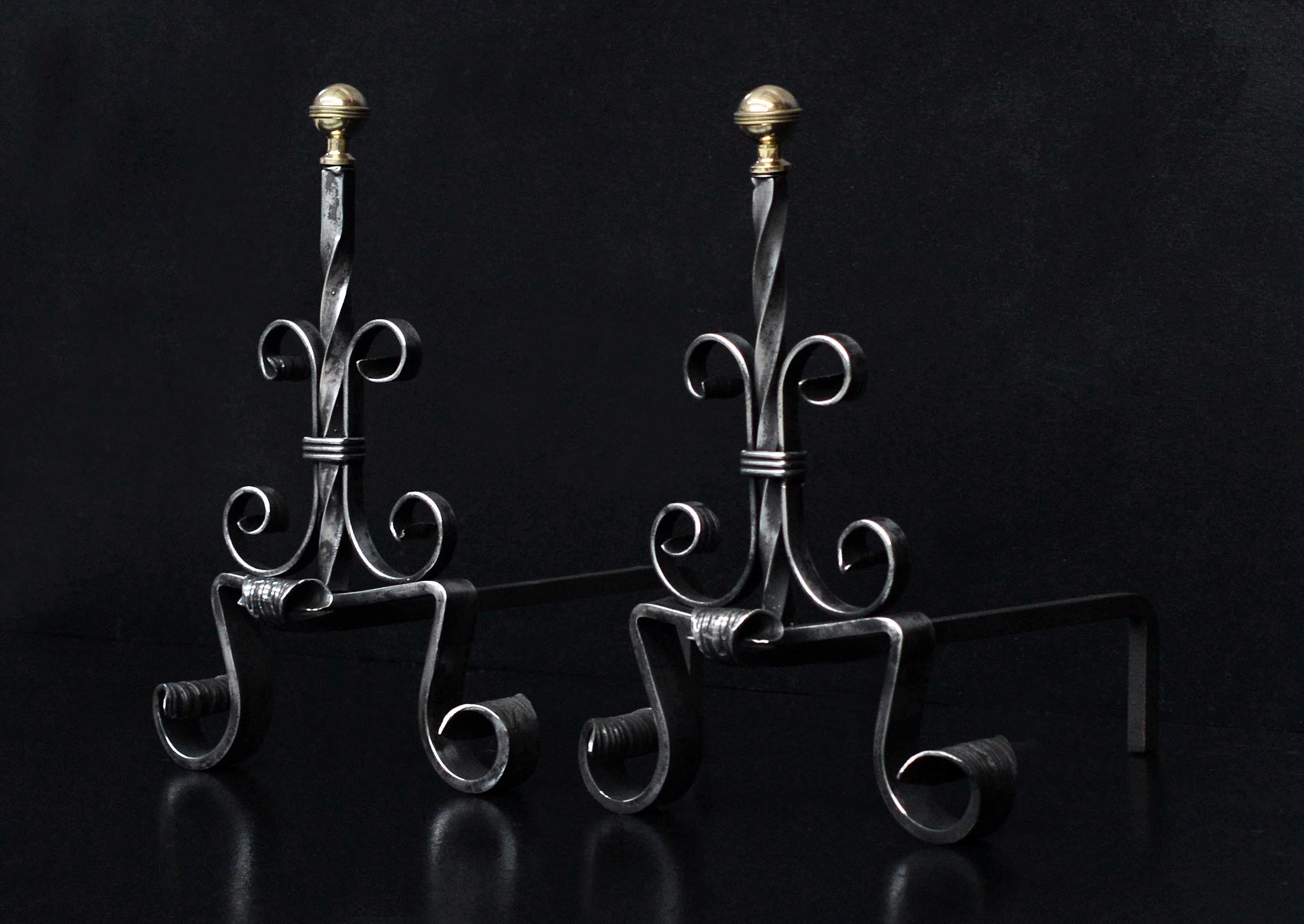 A pair of polished steel firedogs. The scrolled feet surmounted by barley twist shafts and scroll work, with brass ball finials to top. French, 19th century.

Measurements:
Height: 415 mm 16 3/8 in
Width: 300 mm 11 3/4 in
Depth: 395 mm 15 1/2