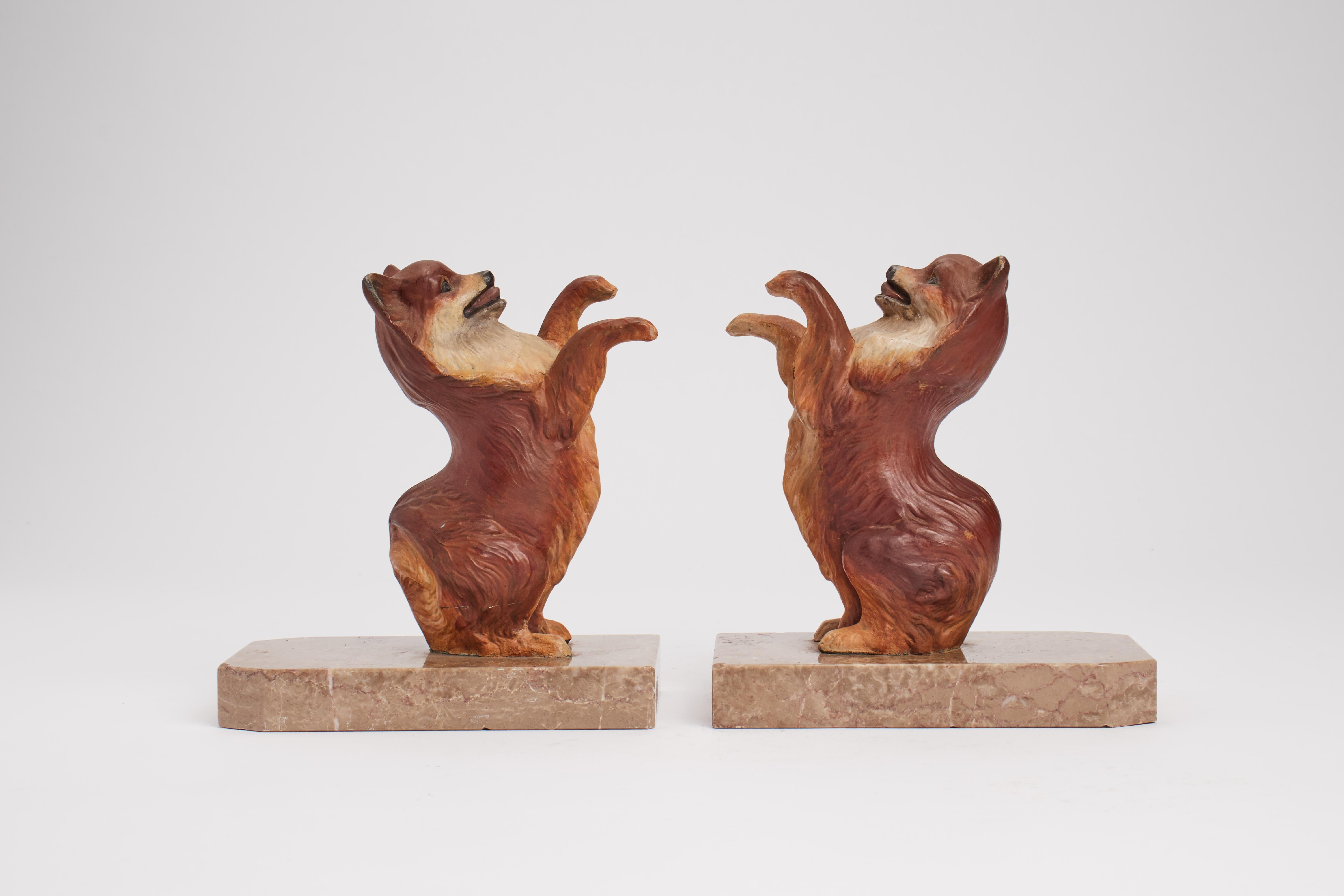 Pair of bookend with enameled metal, depicting Pomeranian dogs sit on marble bases. England circa 1920.