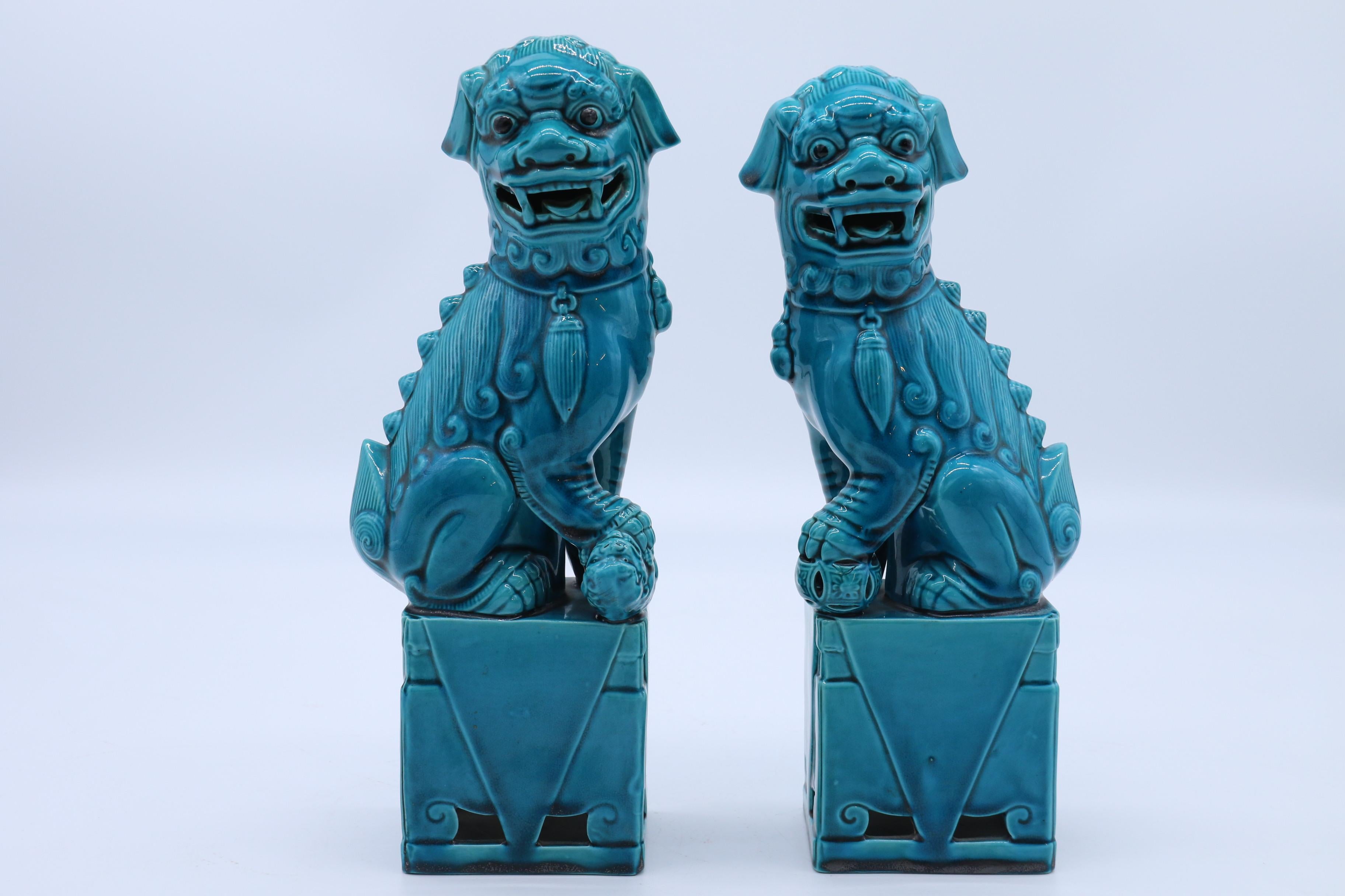 This highly decorative pair of porcelain figures are beautifully modelled with very good detail and depict a pair of Chinese temple Buddhist lions in the classical pose each sitting on a rectangular pedestal with one paw raised. The male is resting