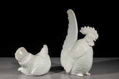 A pair of porcelain okimono depicting a rooster and a hen