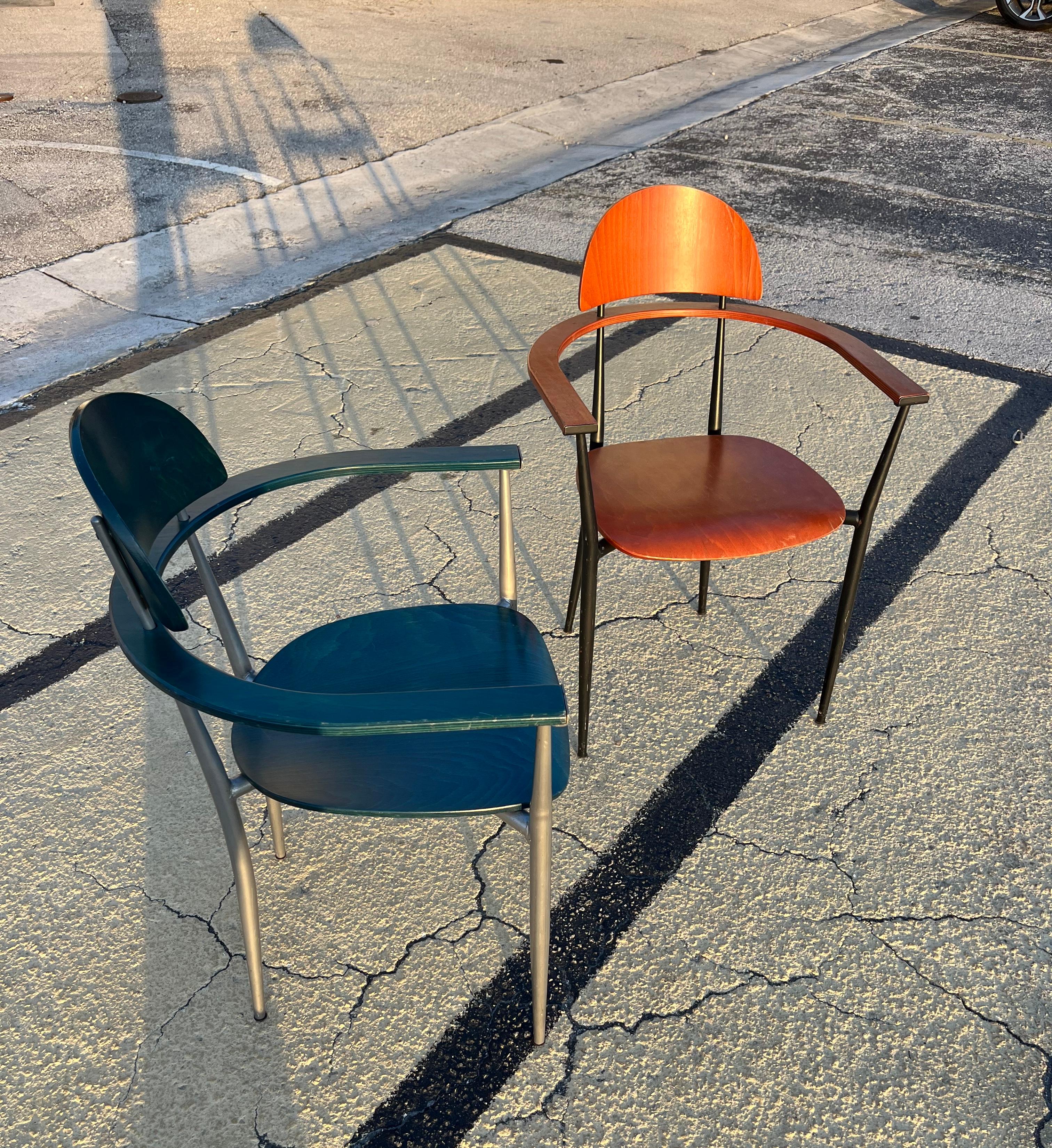 A Pair of Vintage Postmodern Dining / Accent Chairs in the Arrben Stiletto Chairs Style. Circa 1980s 
Feature bent plywood seats, armrests, and backrests with steel frames painted in back and silver color. The chairs come in contrasting burnt orange