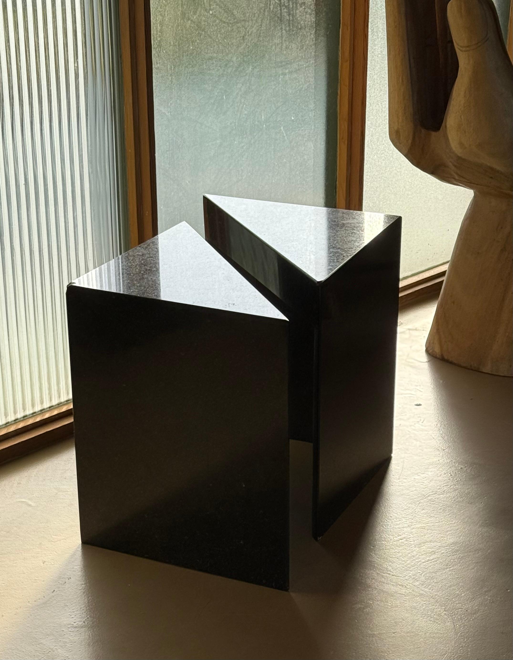 Paire de rares tables d'appoint ou d'appoint triangulaires en granit noir, fin du 20e siècle. Ces superbes tables géométriques proviennent très probablement d'Italie vers 1980. Elles font également office de table de nuit, comme le montrent les