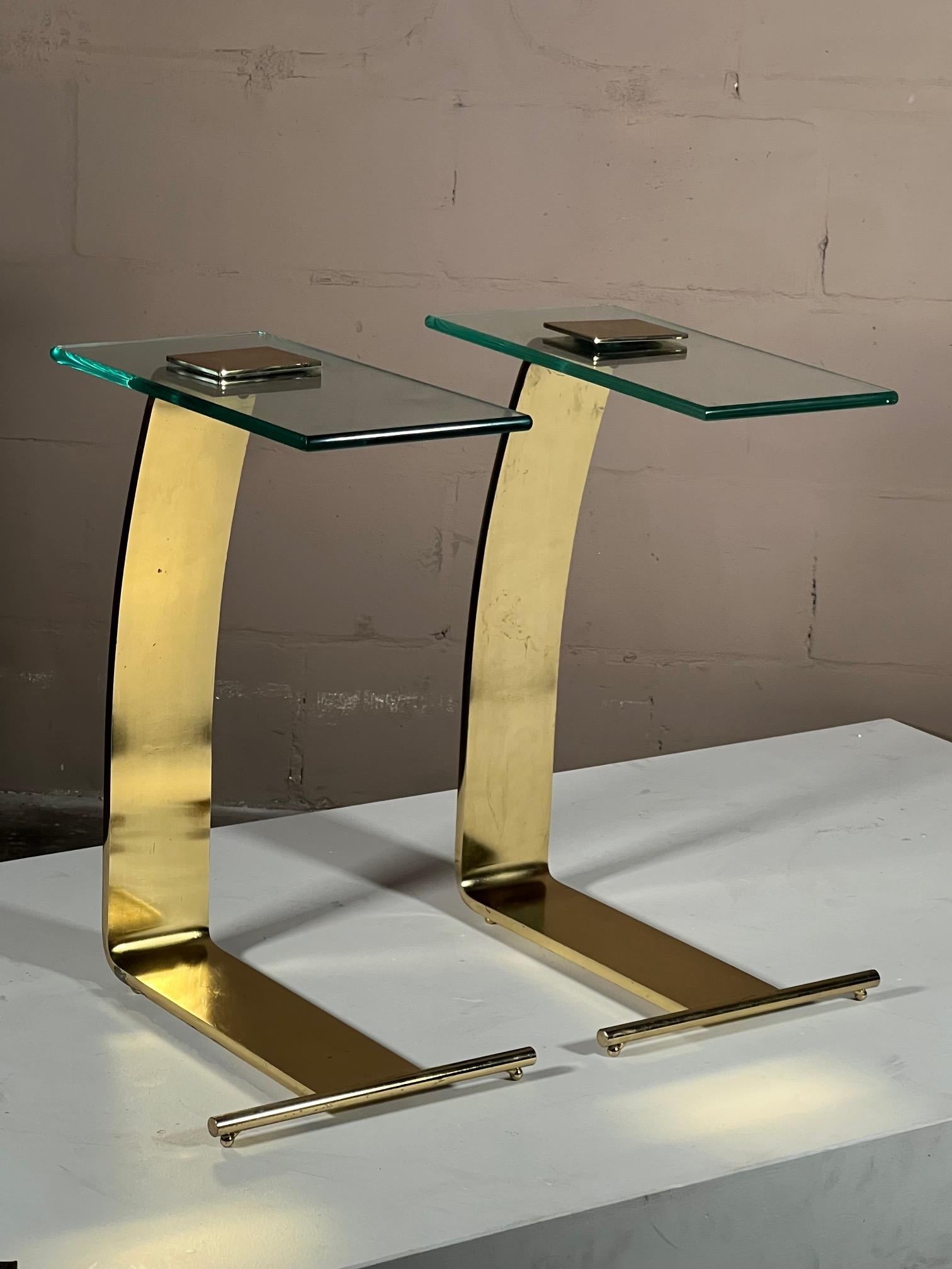 A pair of post modern side tables by Rick Berry for DIA, 1990. Glass with brass plated finish these tables are practical and hard to find as a pair.