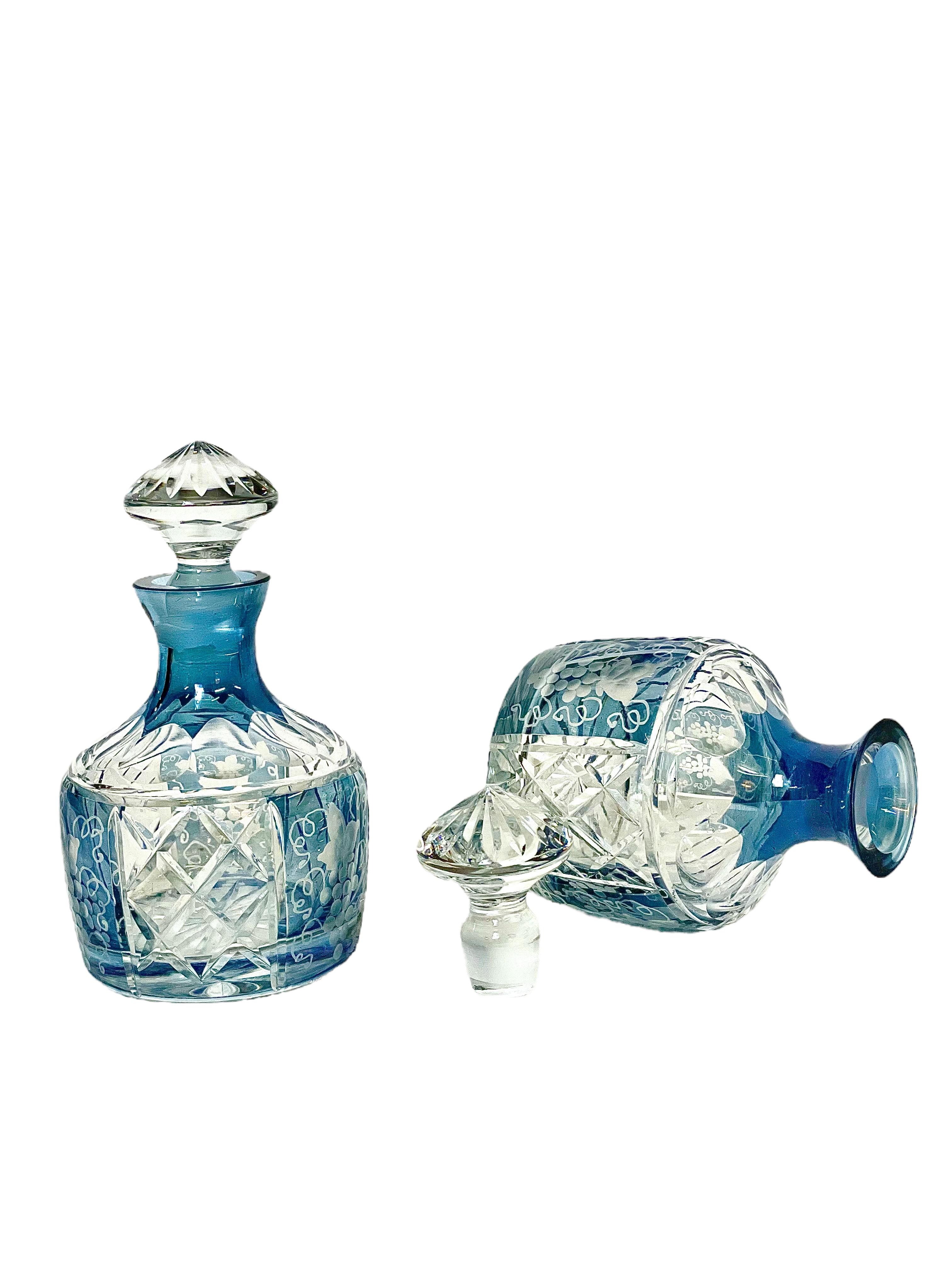 A pair of pretty little cut crystal 'Flacons' with stoppers, in grey cut to clear. The body of the bottles have a beautifully engraved design of vine leaves and grapes interspersed with panels of large diamond shapes. The base and stoppers are both
