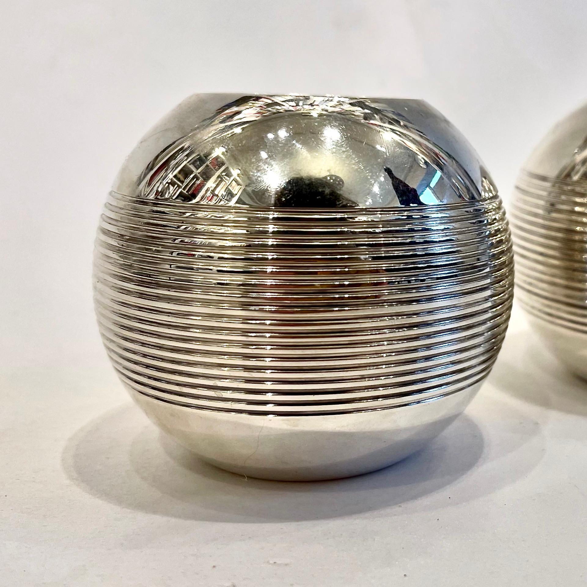 This pair of rounded silver plated candle holders recalls the steel balls used in Pétanque, the traditional game that has delighted Provence natives for centuries. 
Such is the case for these spherical vases, fashioned in mirror-polished