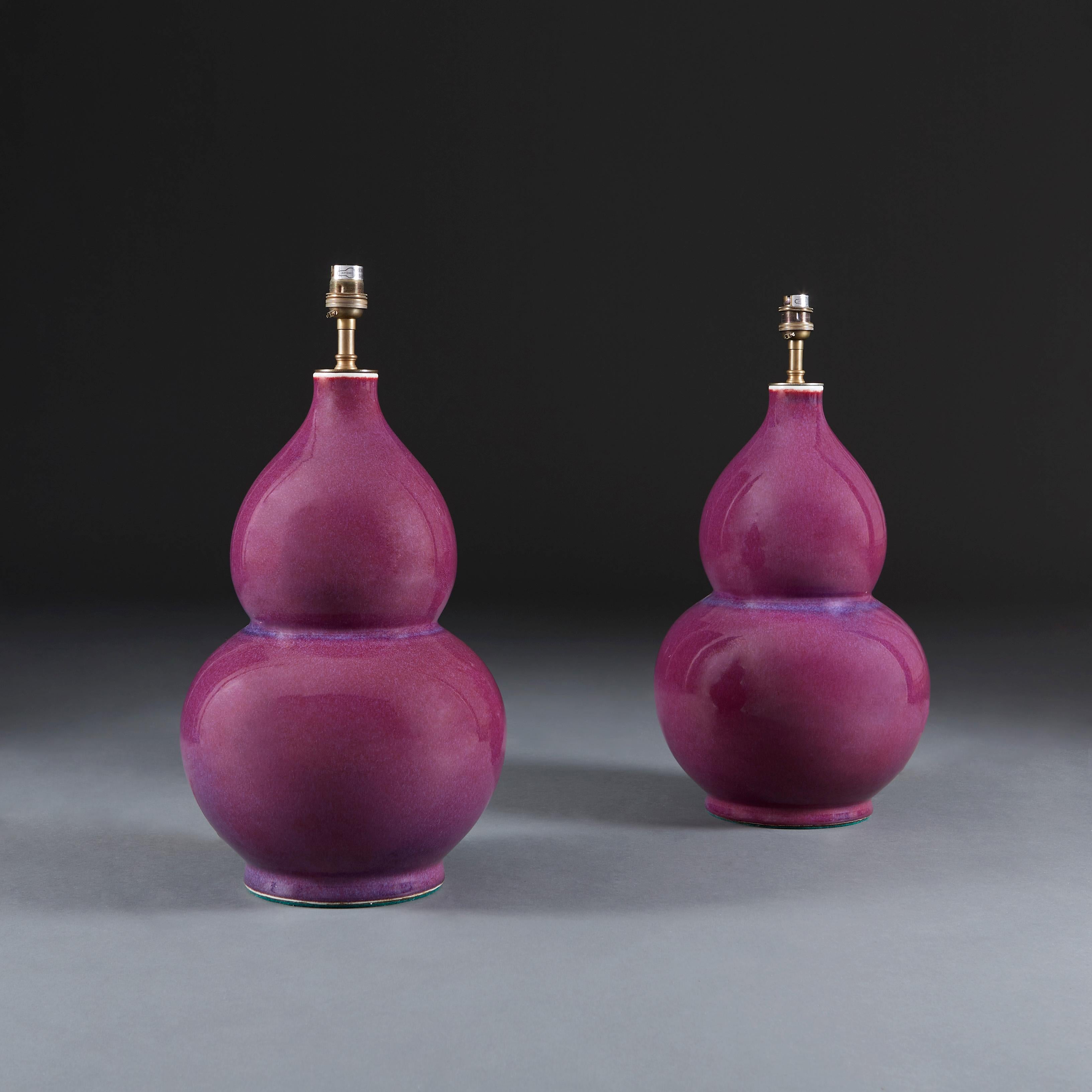 A pair of 20th century Chinese monochrome lamps with strong purple glaze with blue flecks throughout, of double gourd form.

Please note: lampshades not included.

Currently wired for the UK.