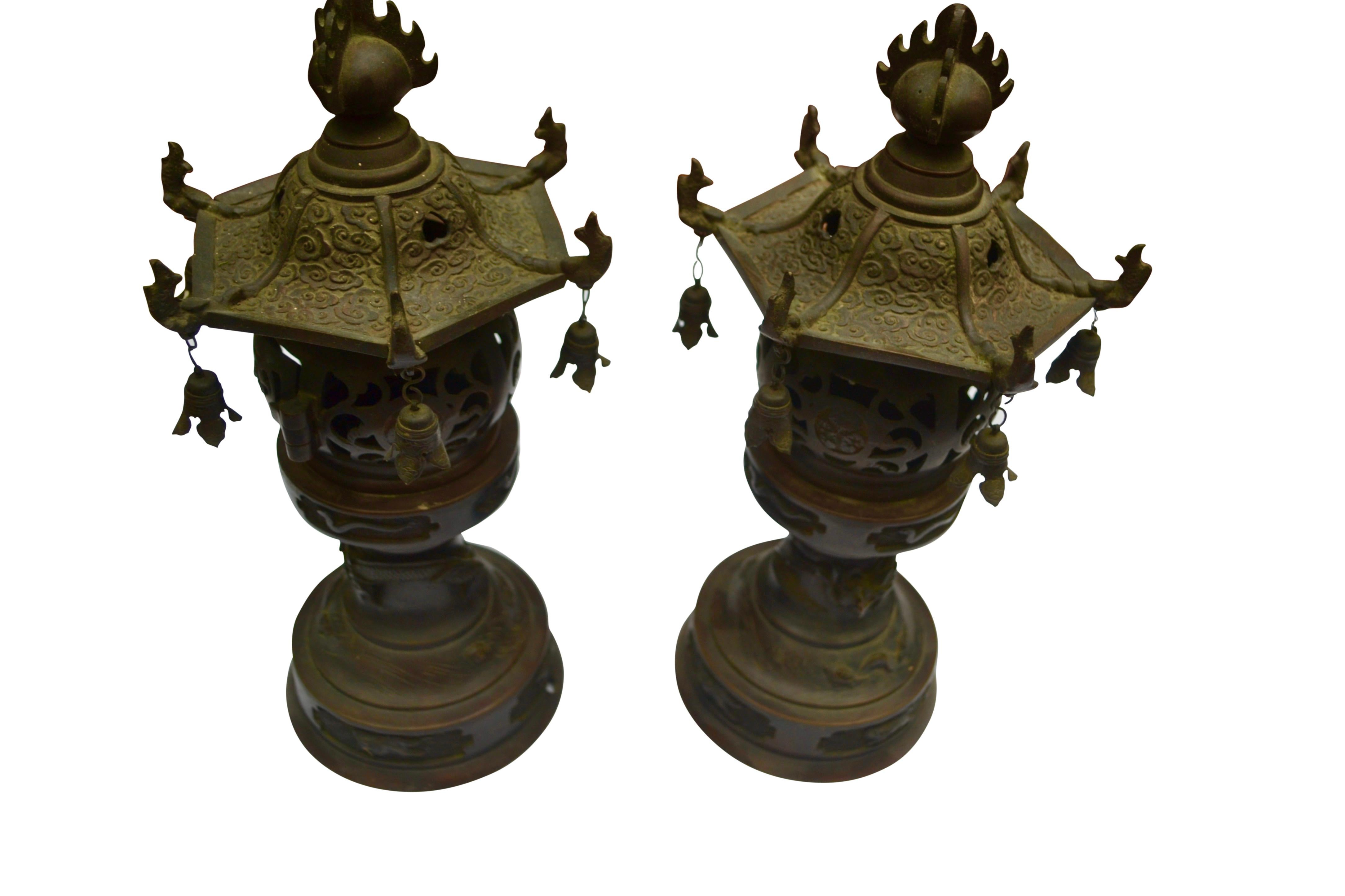 A pair of 19 Century Qing Dynasty Chinese patinated bronze dragon pagoda temple censor / incense burner. The censors are decorated with a high relief flowers , a dragon curling around its base , fish swimming turtles and bells The top cover of the