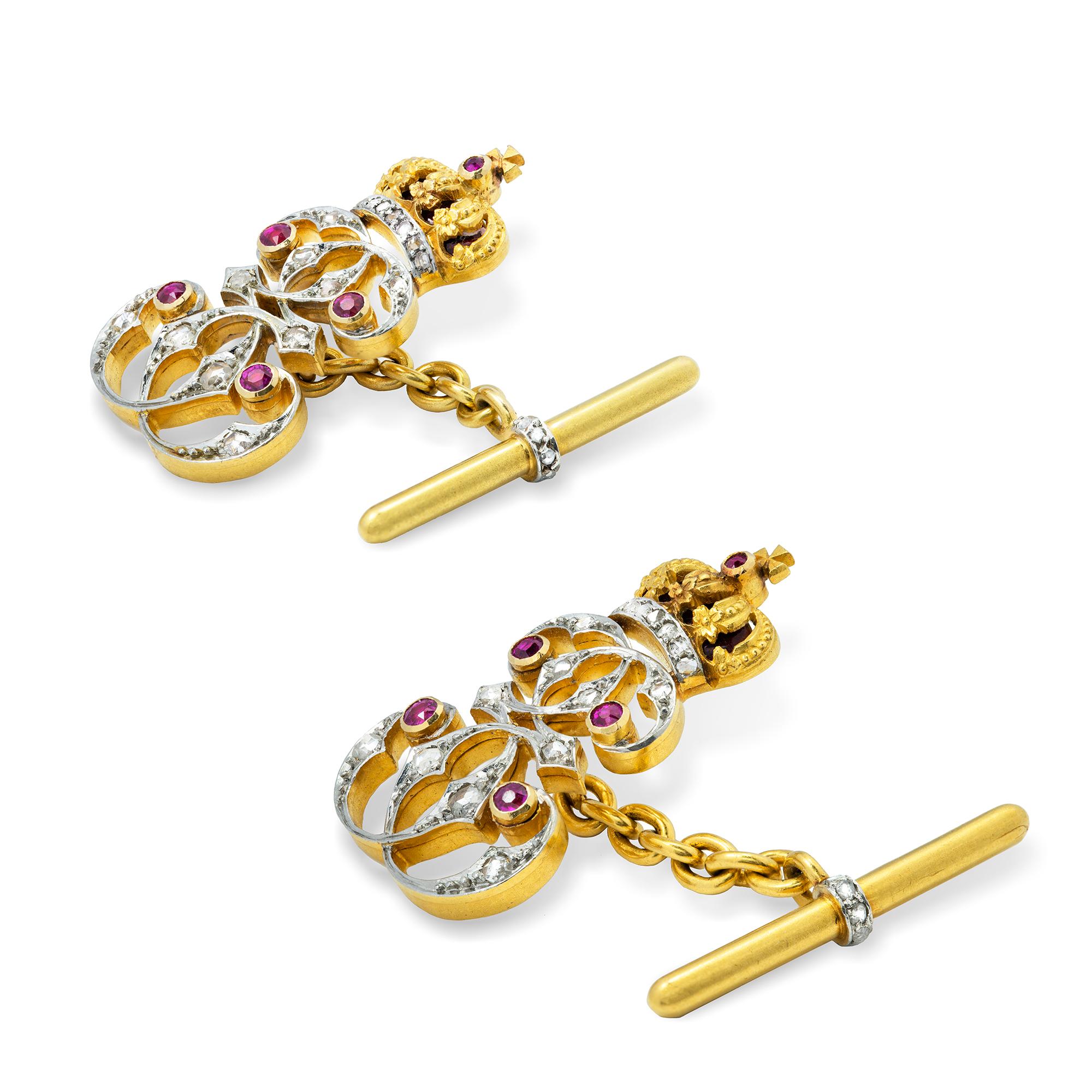 A pair of Queen Elizabeth of Romania presentation cufflinks, the Queen’s cypher encrusted with rose-cut diamonds and rubies set in platinum, with red guilloche enamel decoration on the crown, linked to a cufflink chain and a gold bar with a rose-cut