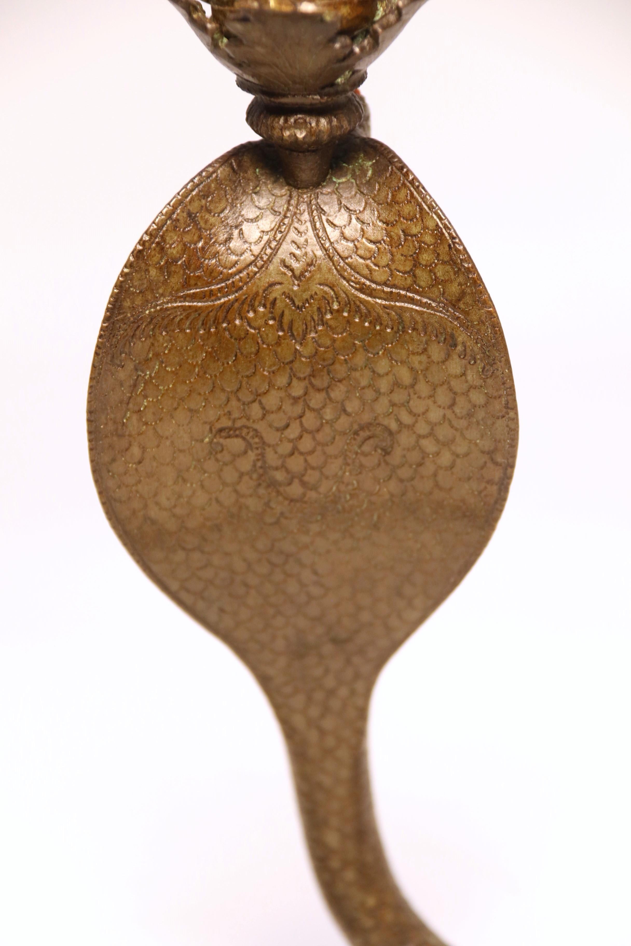 A pair of Raj period Indian bronze candlesticks in the form of striking cobras 11
