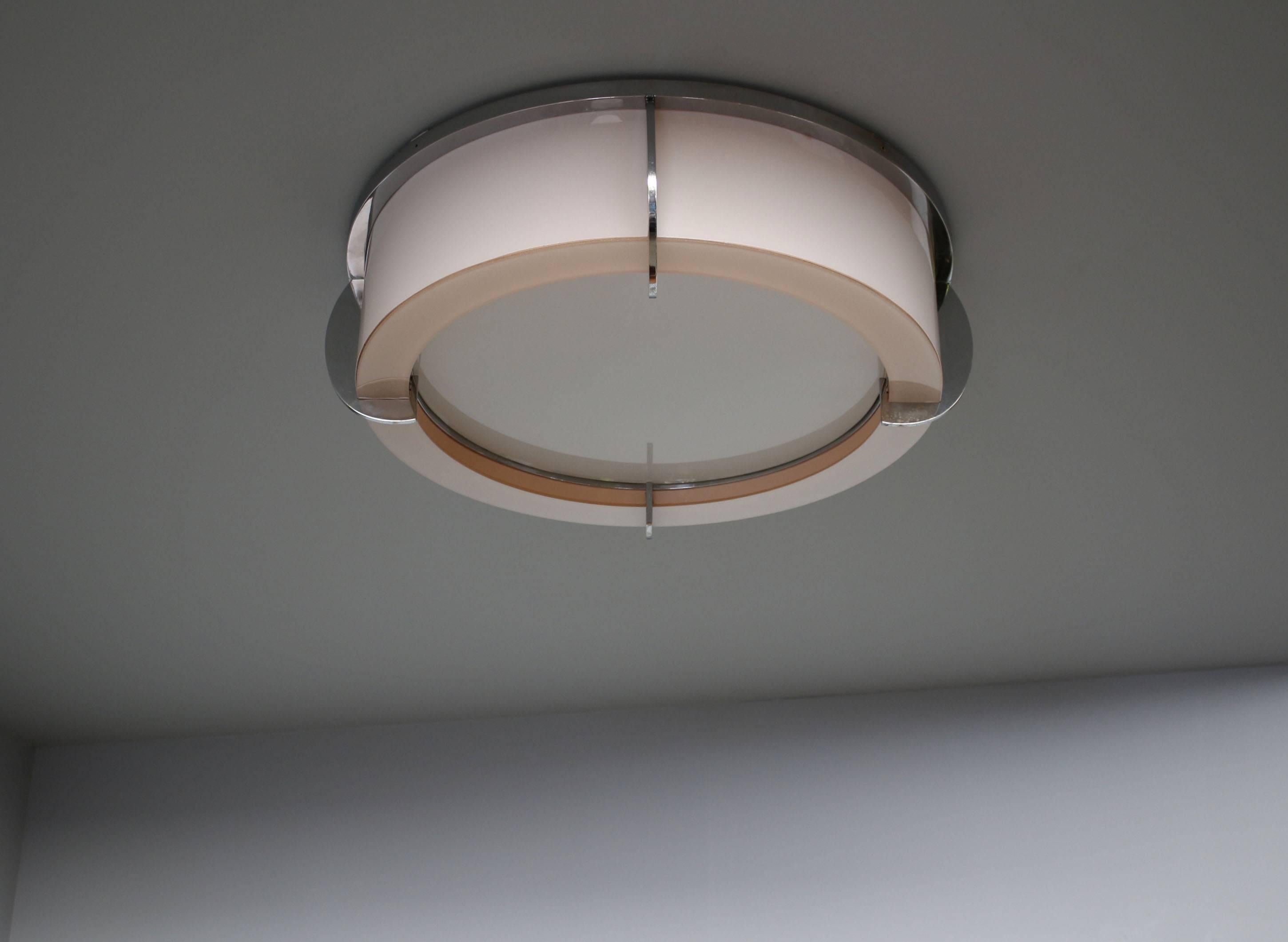 Mounted on chromed crown-shaped frames, the enameled pink and white glass diffusers give off a strong and soft light. The round horizontal diffusers are easily removable in order to change the bulbs.
Diameter at glass parts is 23