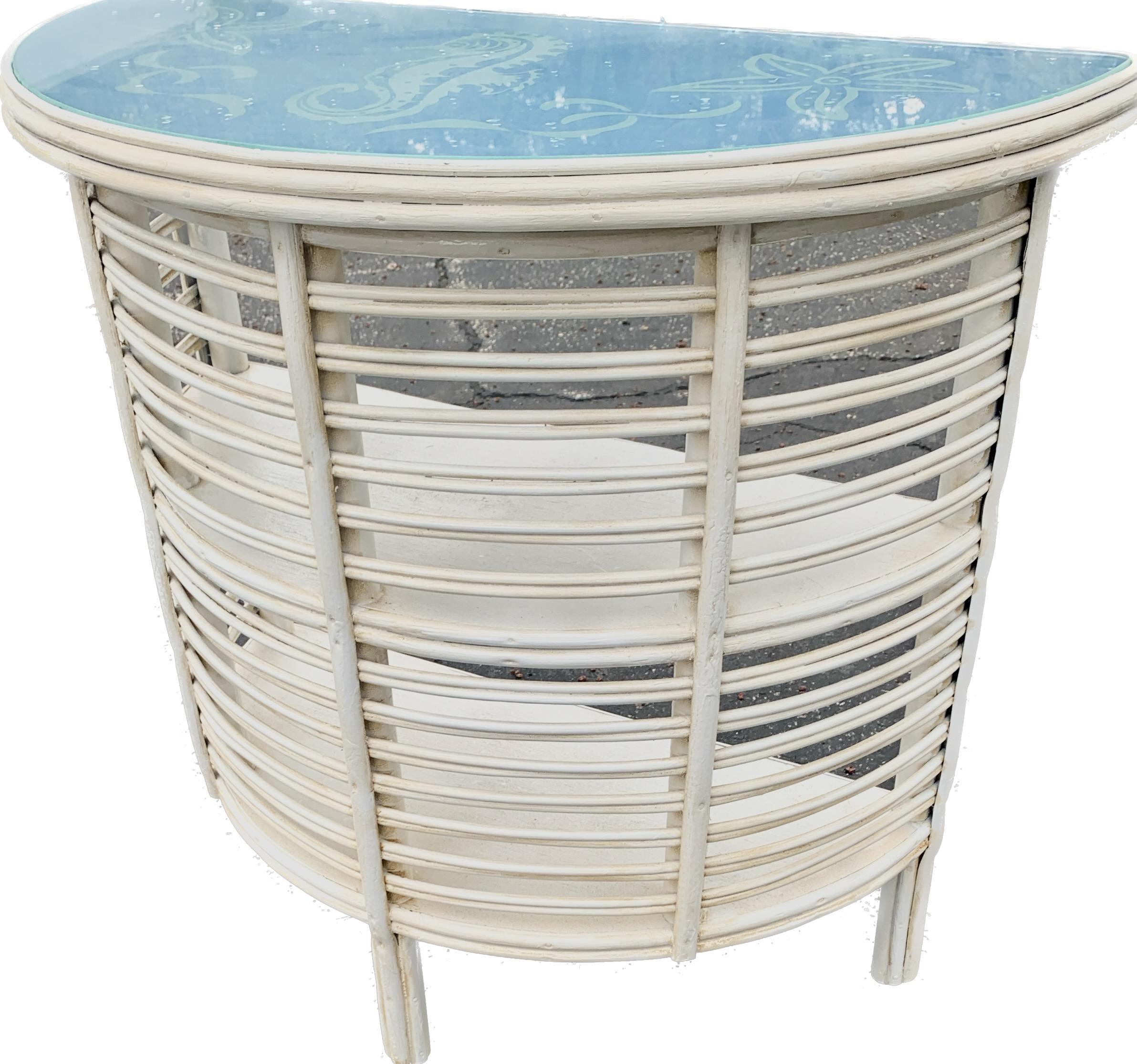A rare pair of Art Deco Rattan Demi Lune side tables attributed to the Heywood Wakefield Company, Gardner, Ma., American, C. 1929,
The tables are done in a white painted finish and are in very good condition.These rattan tables are also referred to