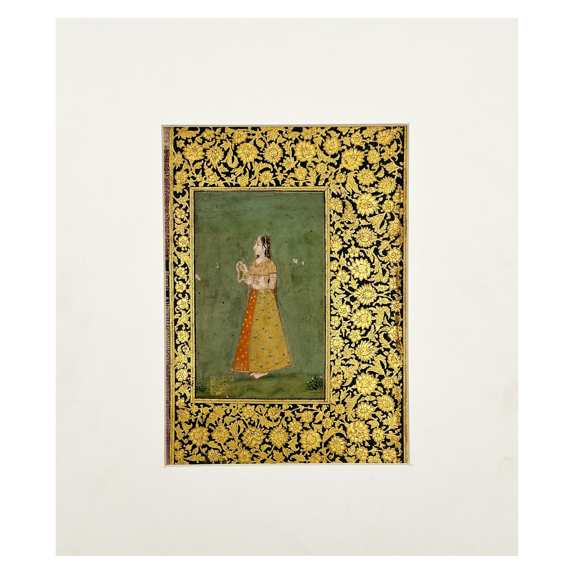 These Indian miniature paintings showcases an elegantly dressed Indian man and a lady, the lady elegantly dressed in a traditional sari and adorned with intricate jewellery, the man wearing traditional clothes and a head turban. The man is holding a