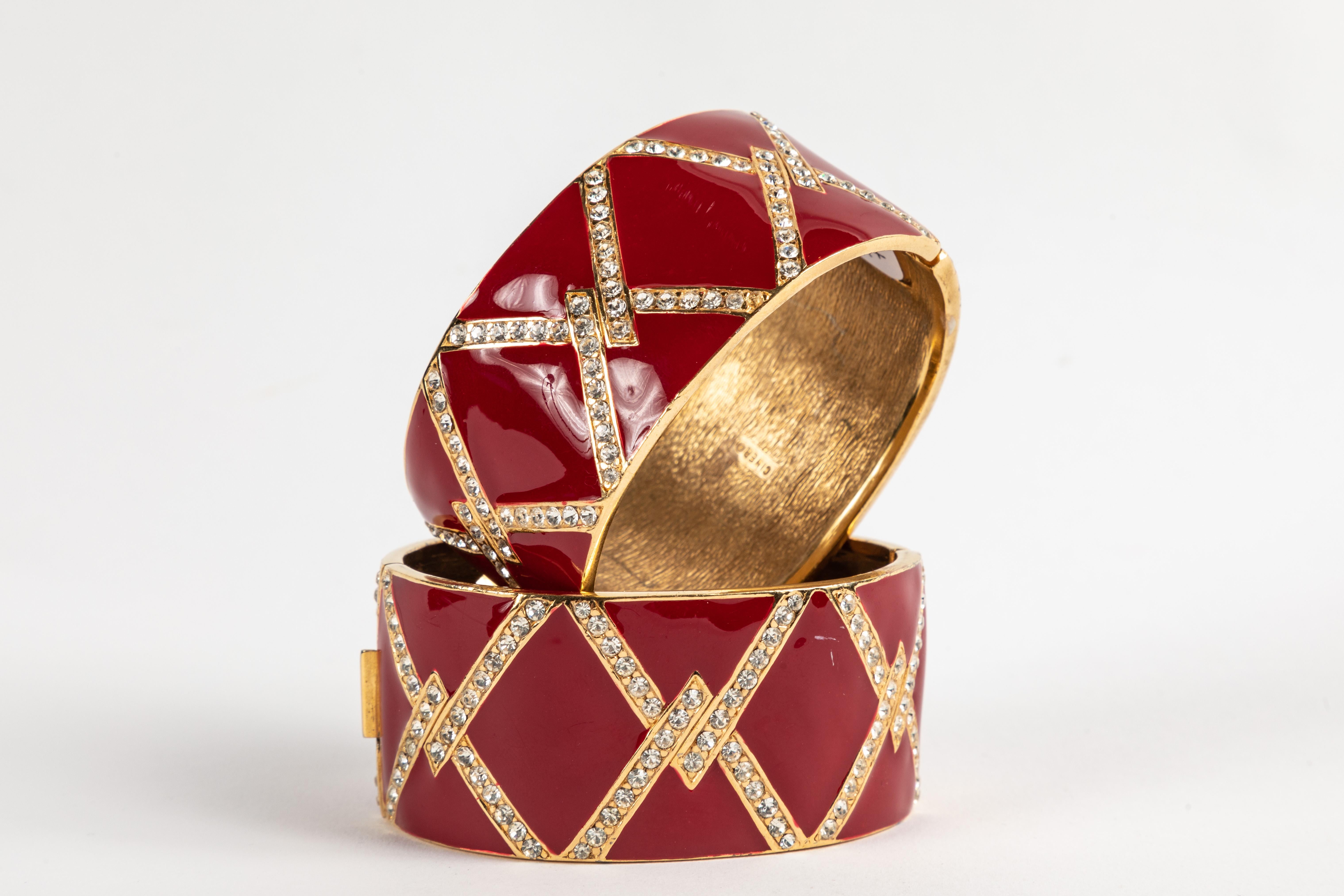 Beautiful matched pair of cuffs with a striking red enamel finish set with brilliant rhinestones set in a gold plated metal.  Signed on the inside 
